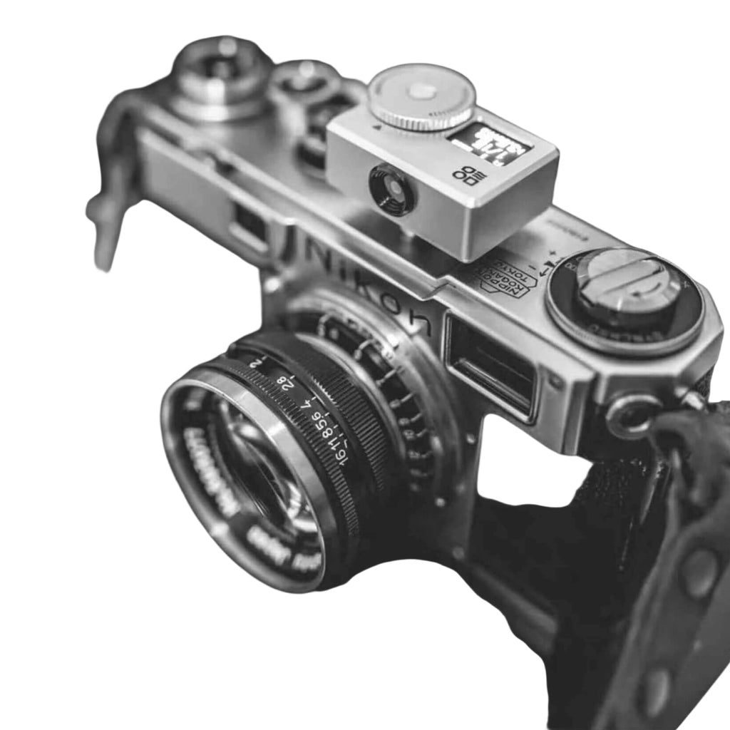 Silver-bodied nikon camera with a mounted lens and top-mounted viewfinder.