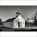 A small, white adobe church with a bell tower topped by a cross.