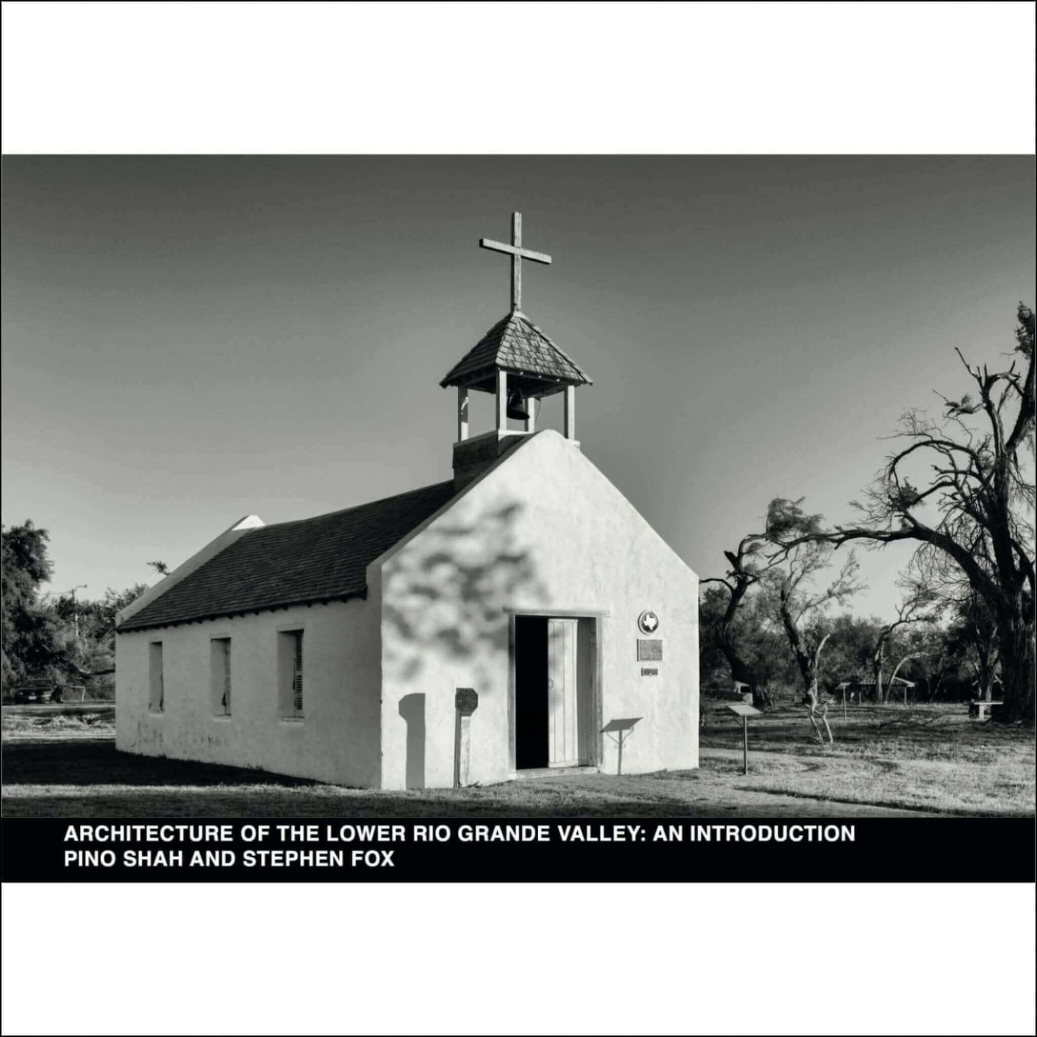 A small, white adobe church with a bell tower topped by a cross.