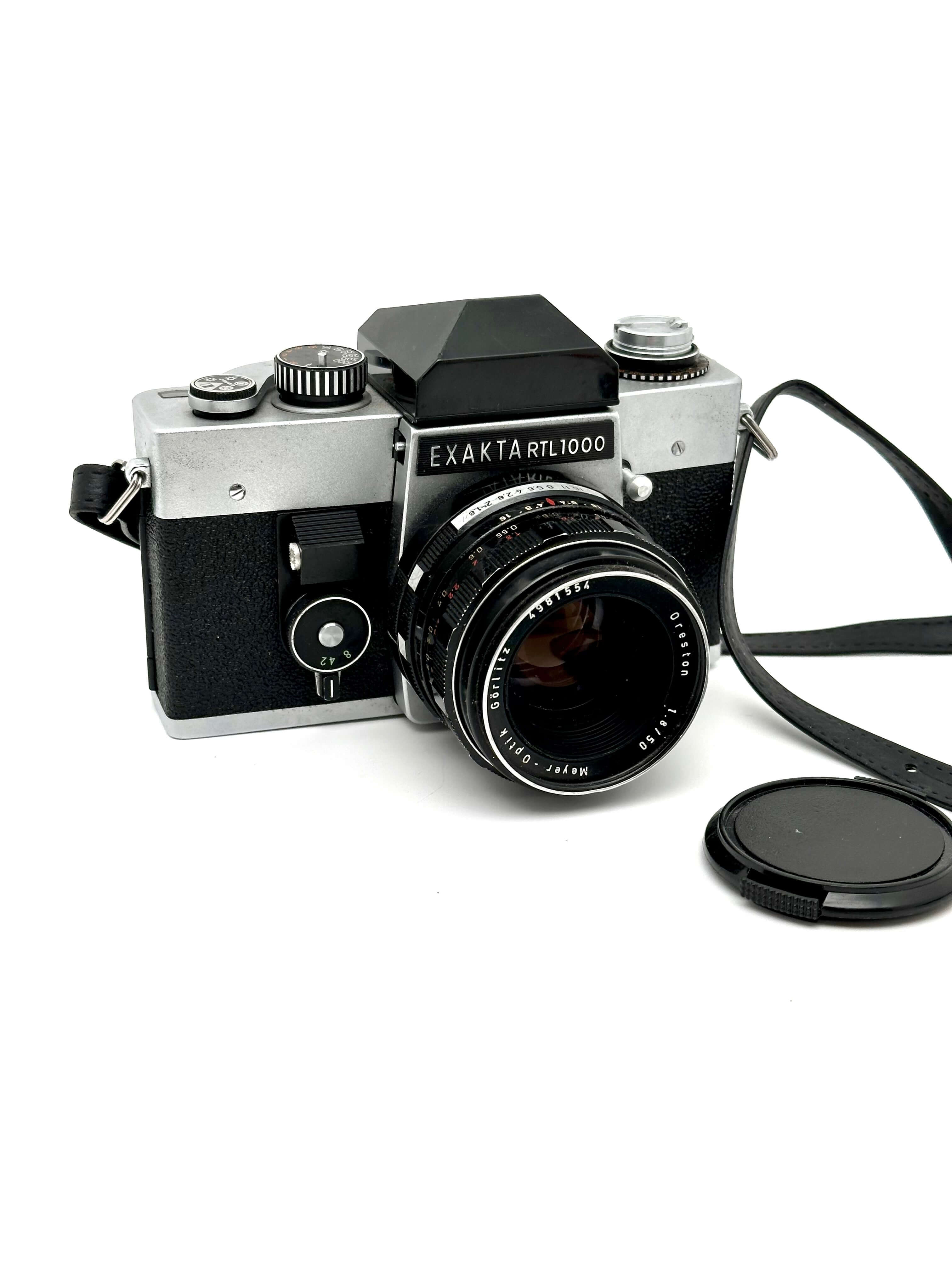 Exakta RTL 1000 vintage 35mm SLR camera with lens and cap, showcasing classic design from Pentacon.