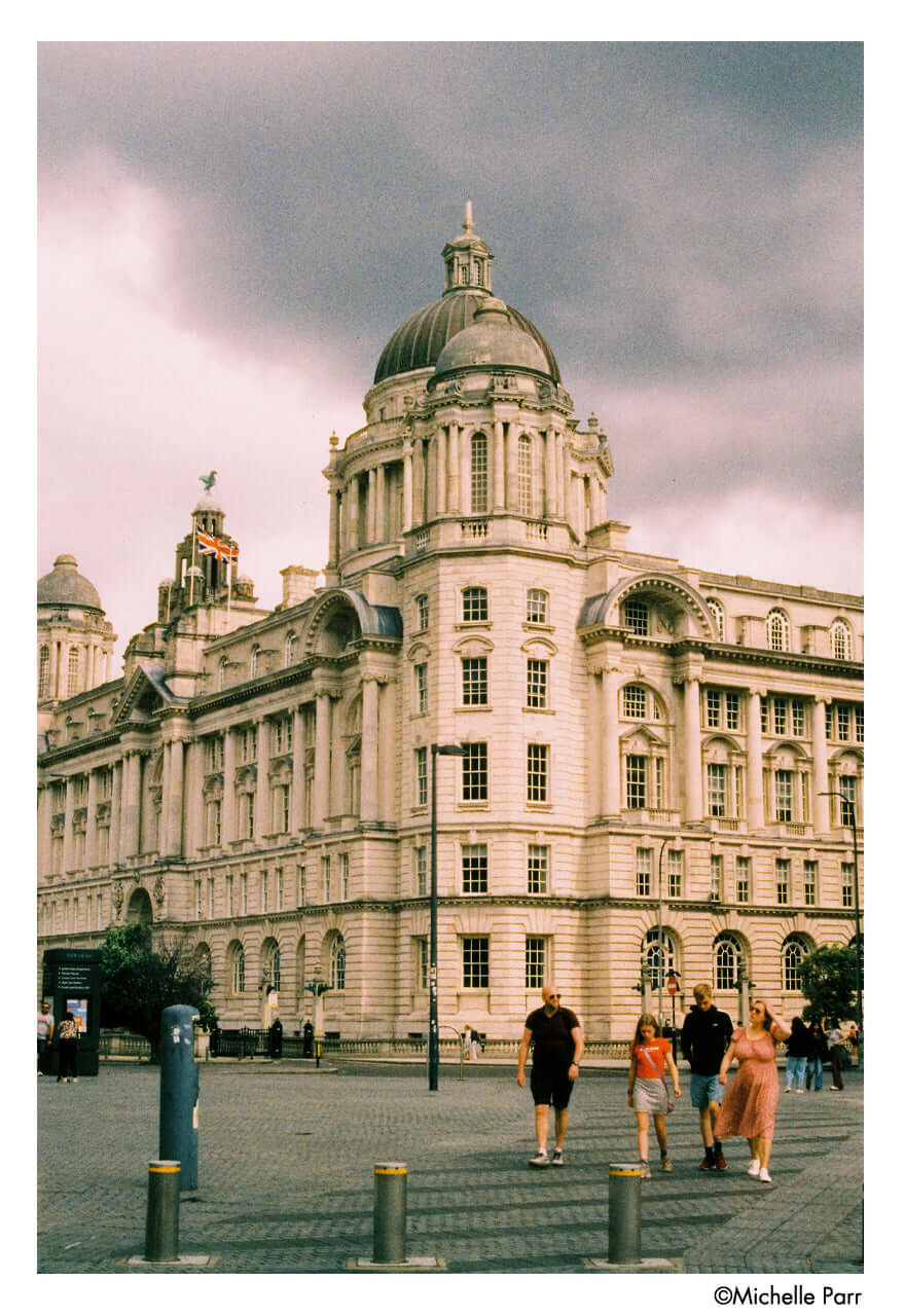 The grand, light-colored stone building with a prominent central dome and ornate architectural details.