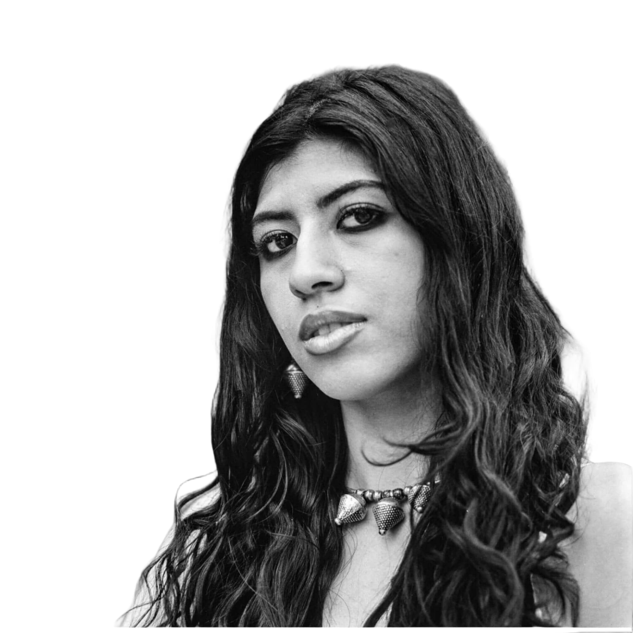 A black-and-white portrait of a woman with long, wavy hair wearing an ornate metallic necklace.