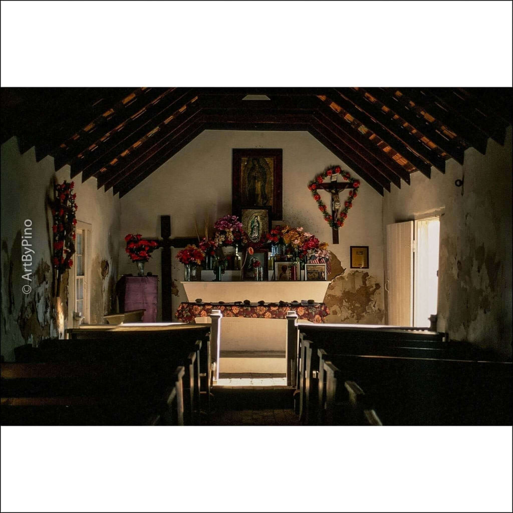 A wooden altar adorned with vibrant red and pink flowers, framed by a dark cross and surrounded by religious icons.