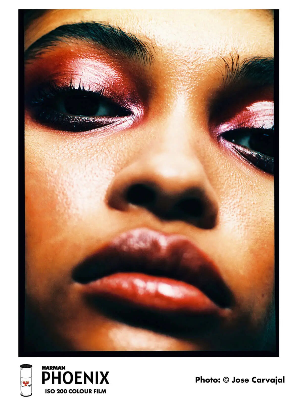 A close-up portrait photograph featuring bold, shimmering red and pink eyeshadow with black eyeliner.