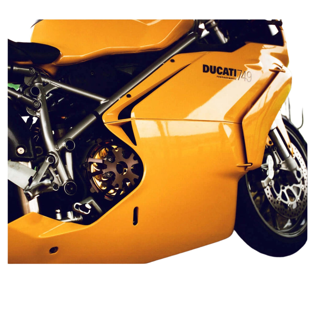 Vibrant orange ducati 749 sport motorcycle with sleek metallic bodywork and exposed mechanical components.