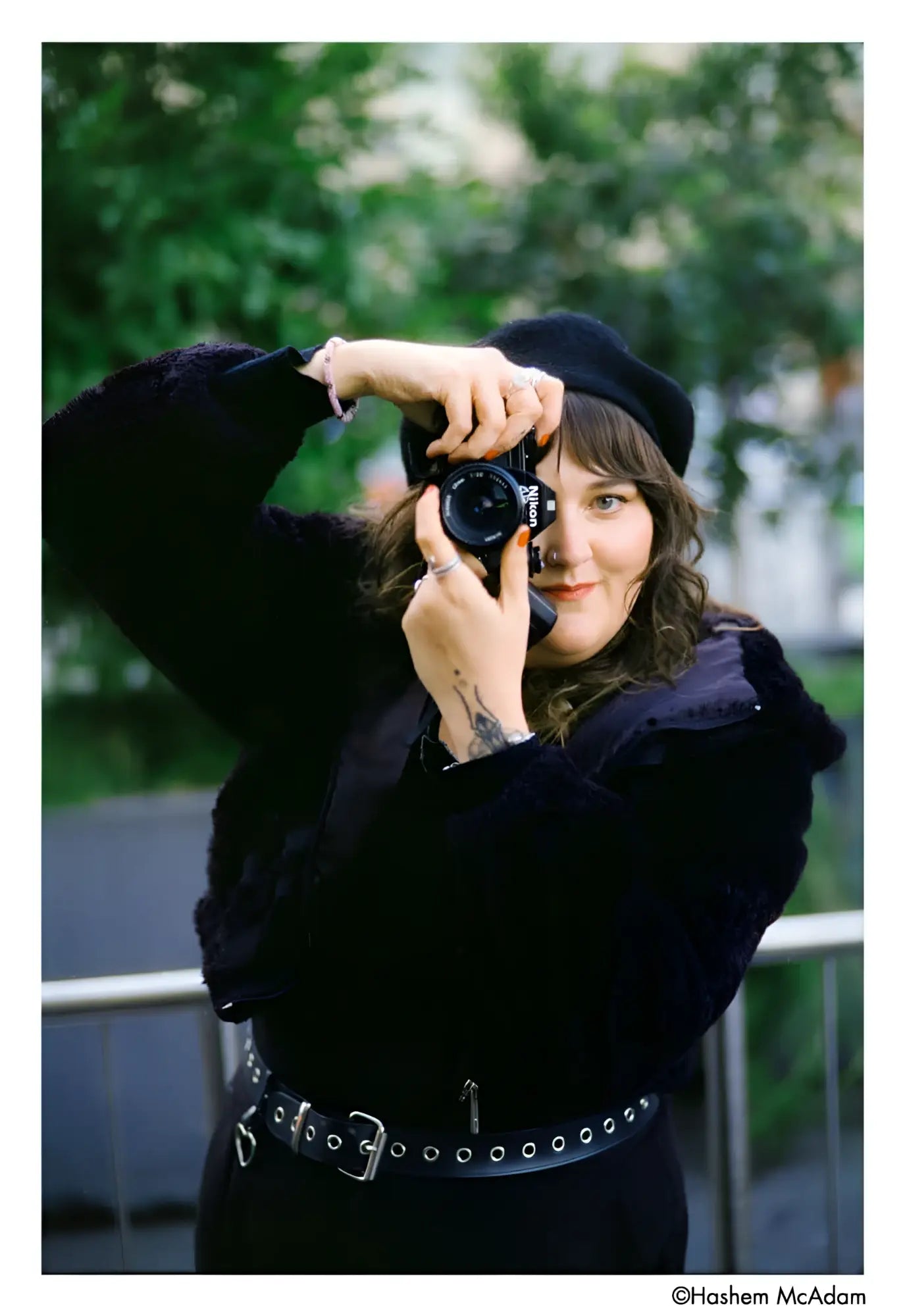 Black nikon camera with a lens cap on the front