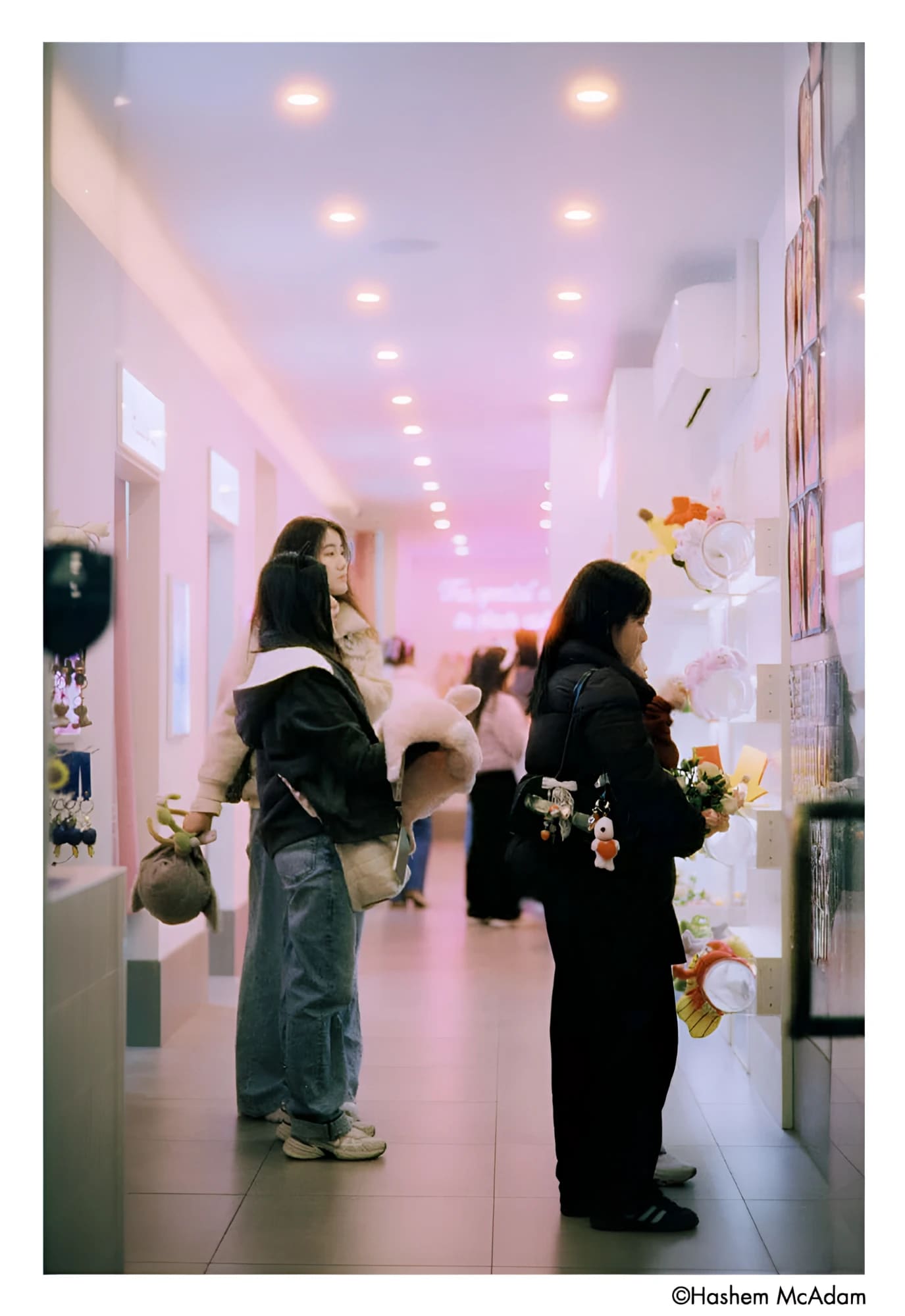 The image shows a hallway with people browsing merchandise, but no single main object is clearly identifiable as the focus of the scene.