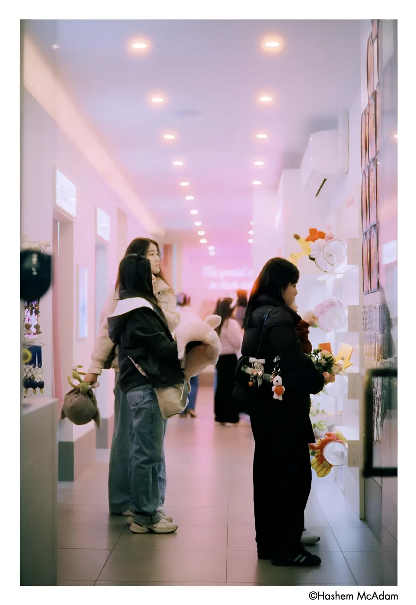 The image shows a hallway with people browsing merchandise, but no single main object is clearly identifiable as the focus of the scene.