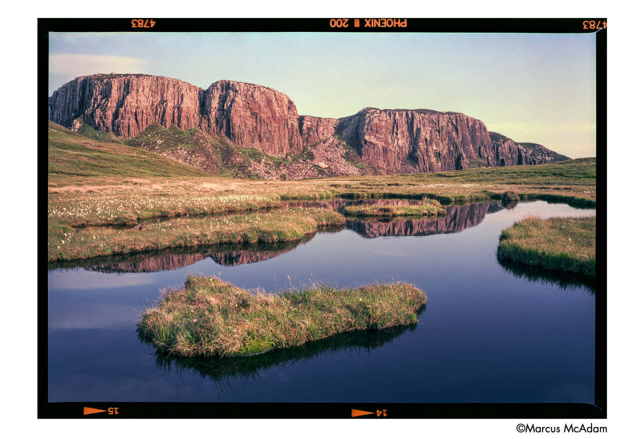 Harman Phoenix II 200 ISO Color 120 Medium Format Film capturing serene landscape with rocky cliffs and reflective water.