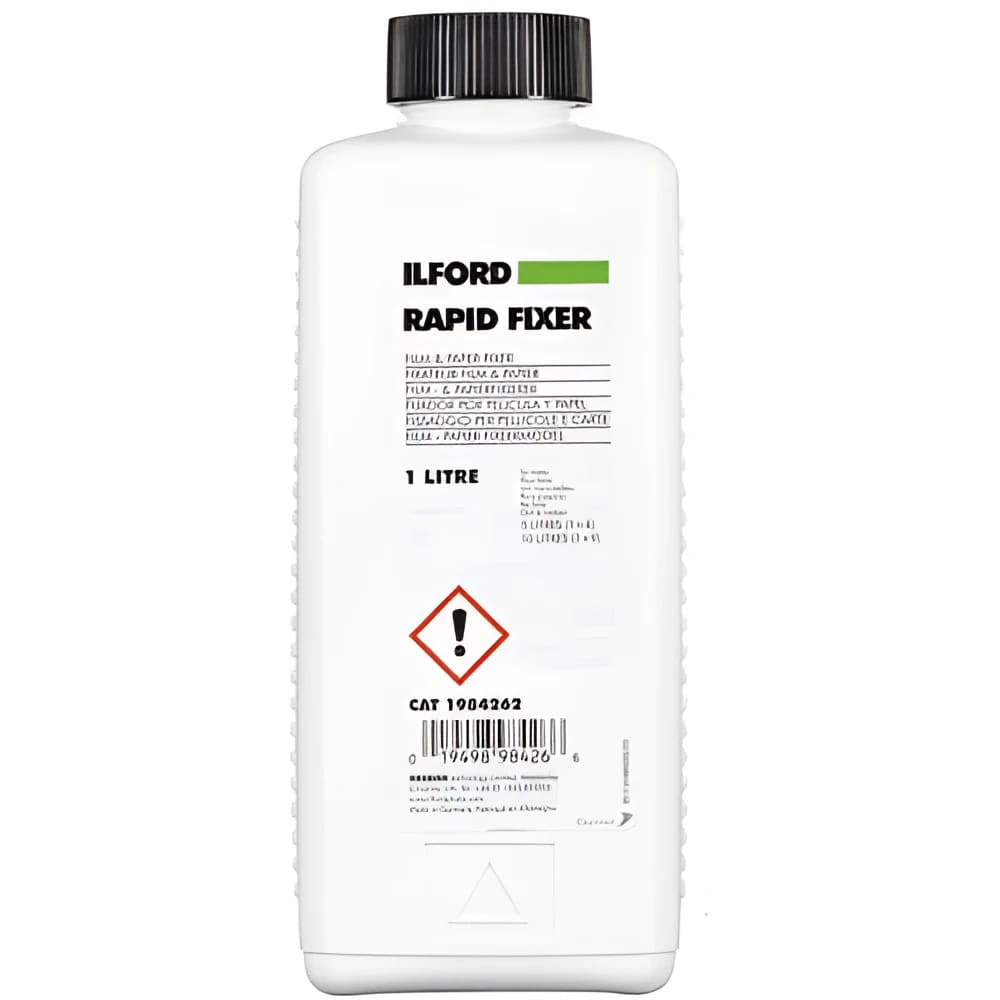White plastic bottle with black cap, labeled ’ilford rapid fixer’ in bold green and black text.