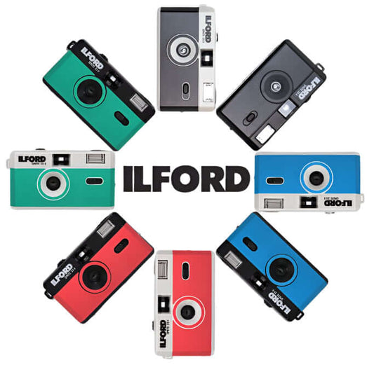 Colorful Ilford Sprite 35-II reusable cameras arranged around the Ilford logo, showcasing analog photography charm.