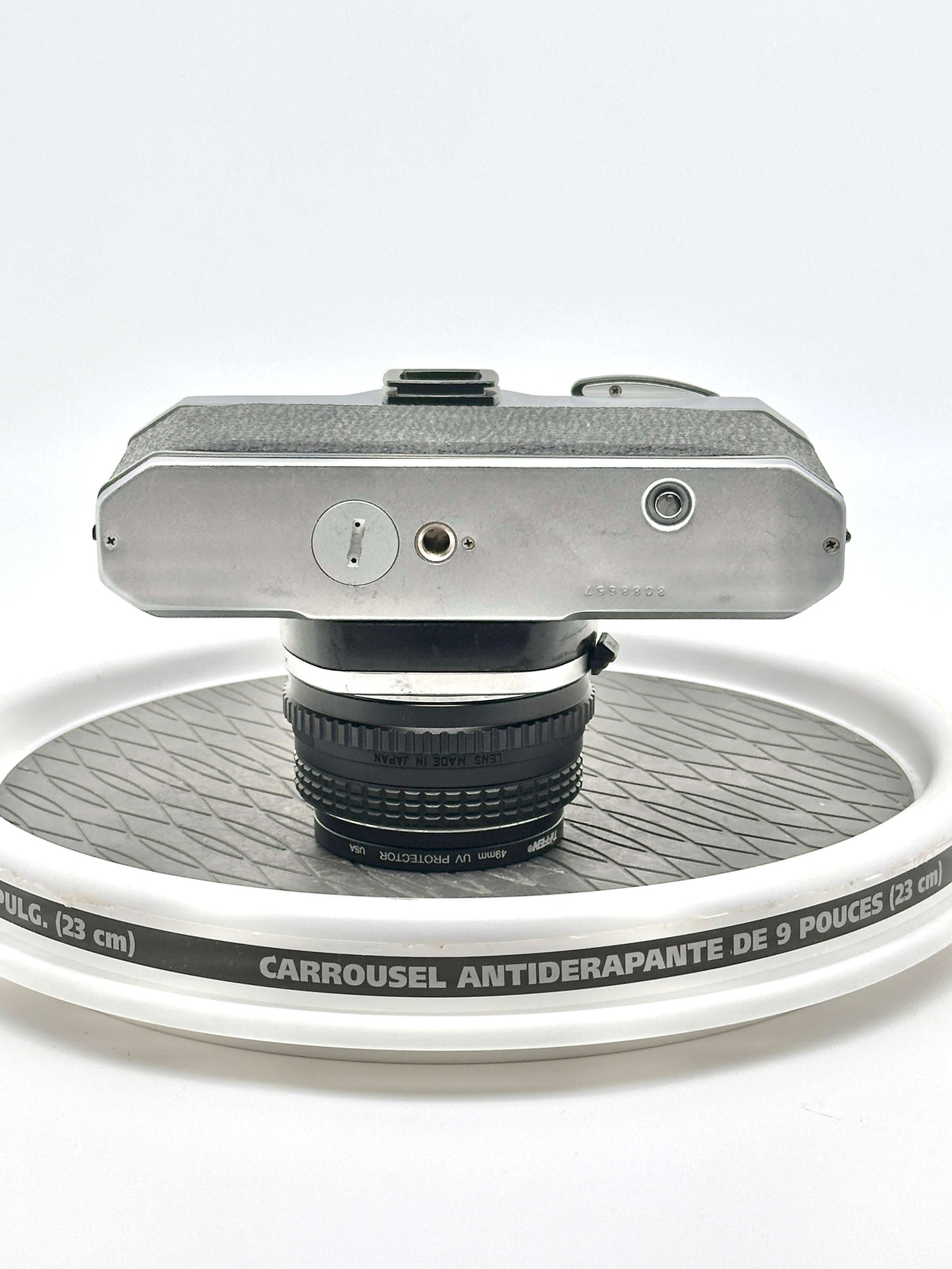 Pentax K1000 black 35mm film camera viewed from above with 50mm f1.7 lens on a display turntable.