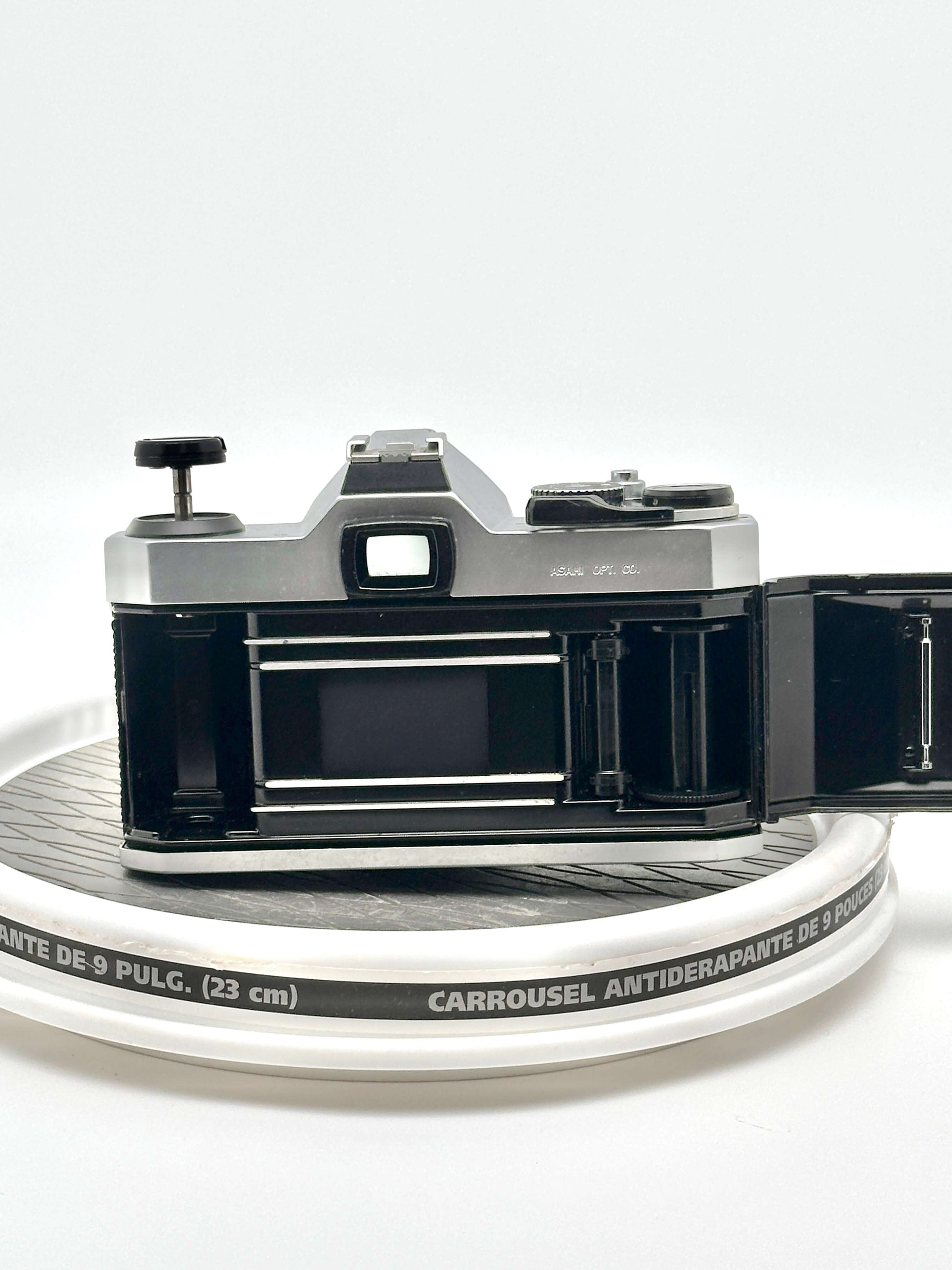 Back view of a used Japanese Asahi Pentax K1000 35mm film camera, showing the open film compartment.