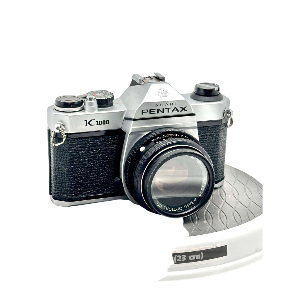 Silver and black asahi pentax k1000 film camera with a textured grip and classic rangefinder design.