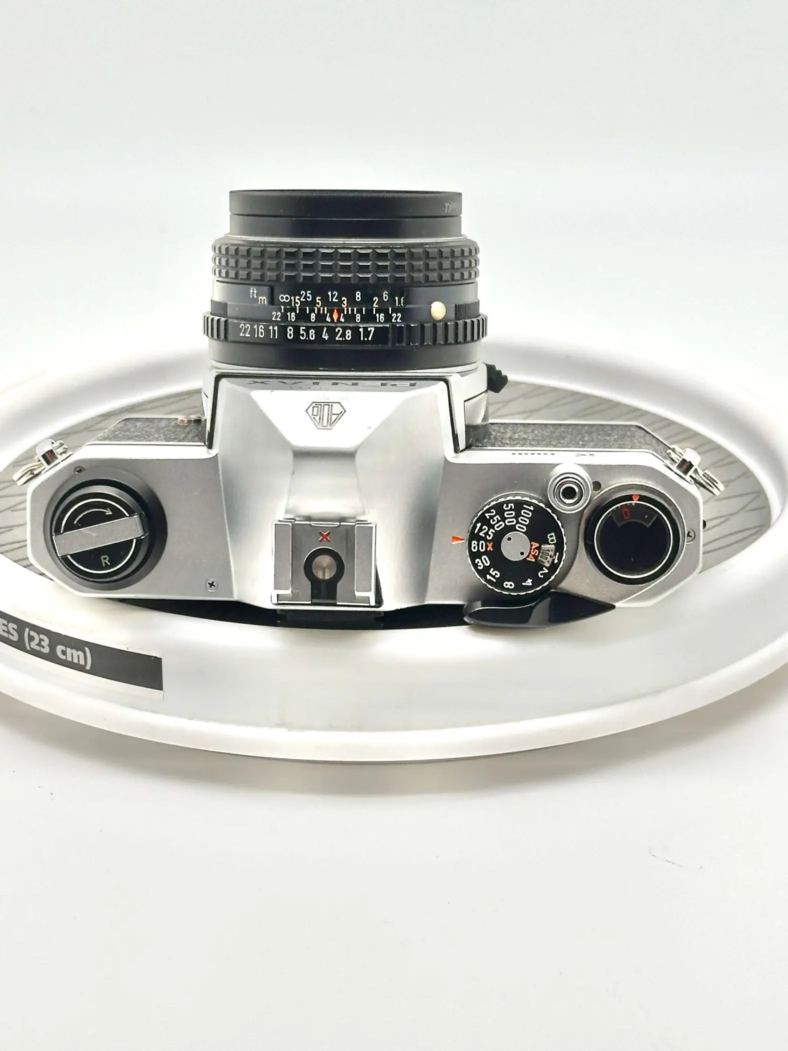 Silver-bodied canon ae-1 film camera with a black lens and textured grip.