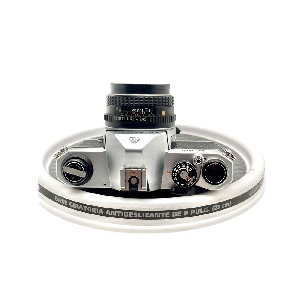 Silver-bodied canon ae-1 film camera with a black lens and textured dials.
