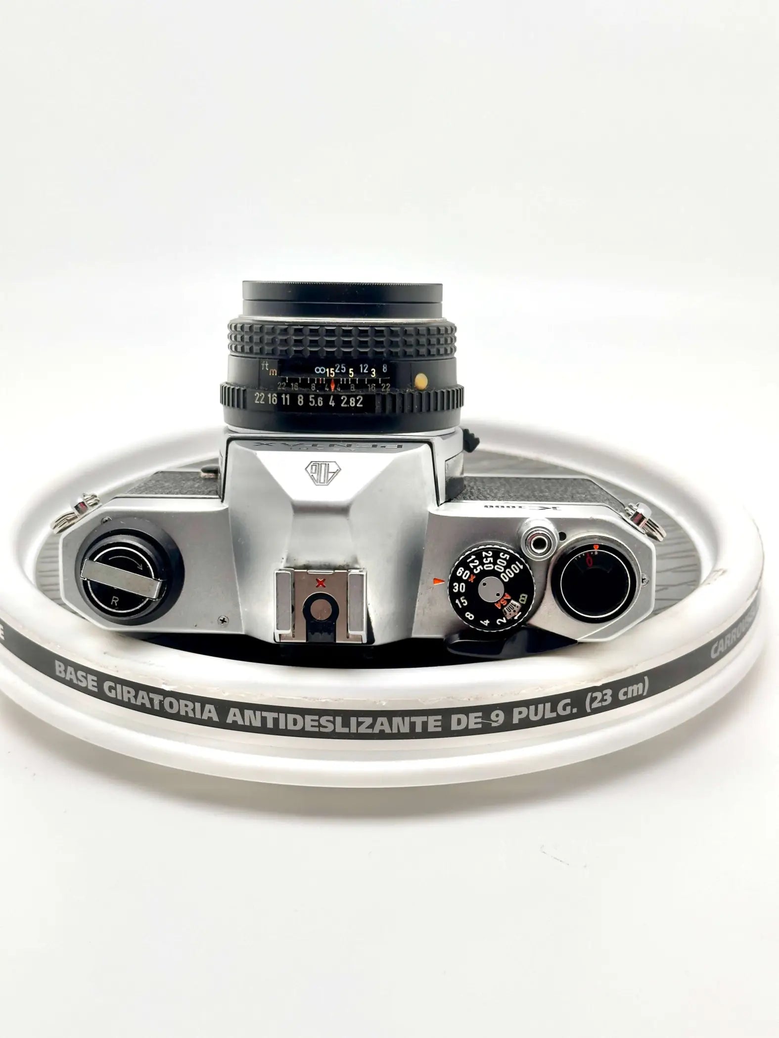 Silver-bodied canon ae-1 film camera with a black lens and textured dials.