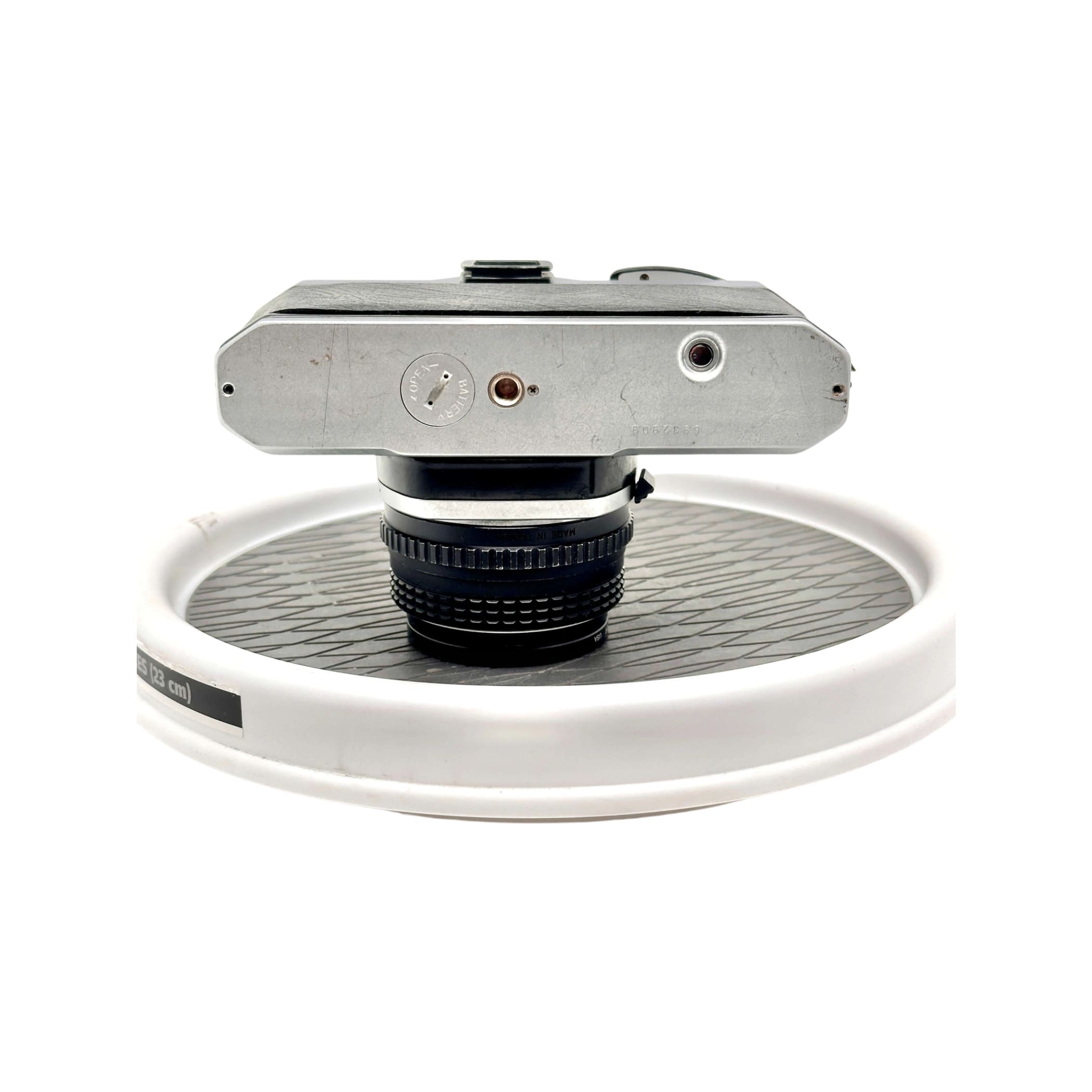 Silver-bodied nikon fm2 film camera with a black lens mounted on top.