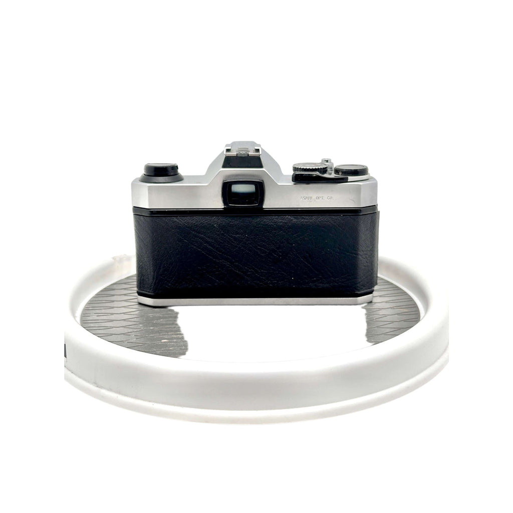 Silver and black canon ae-1 film camera with a textured leather body.