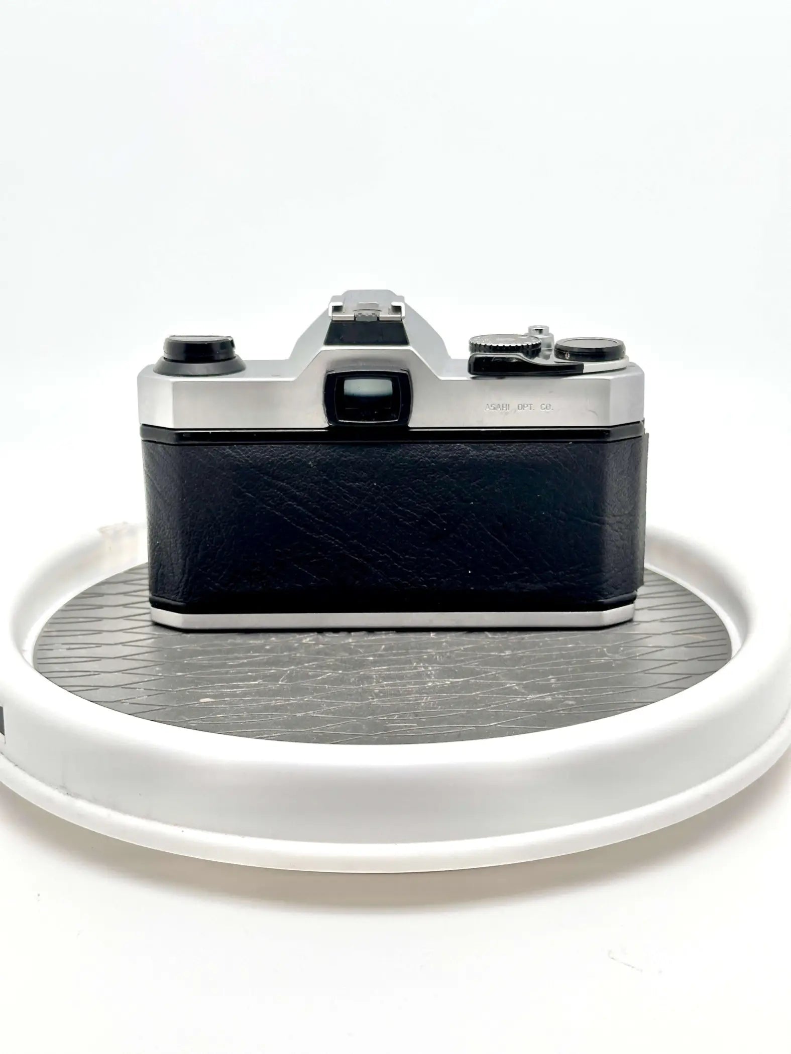 Silver and black canon ae-1 film camera with a textured leather body.