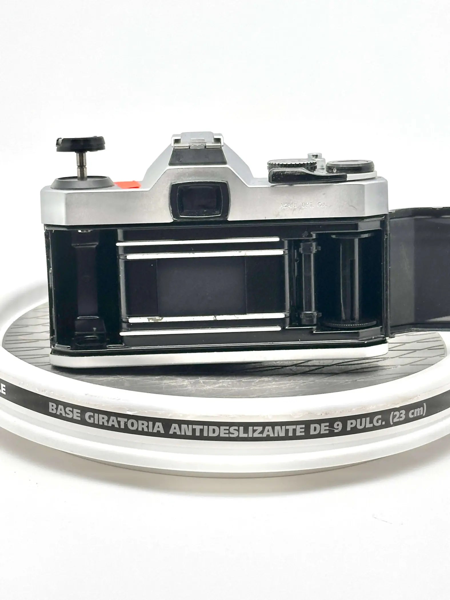 Silver and black vintage film camera with a metallic body, exposed shutter mechanism, and visible lens mount.