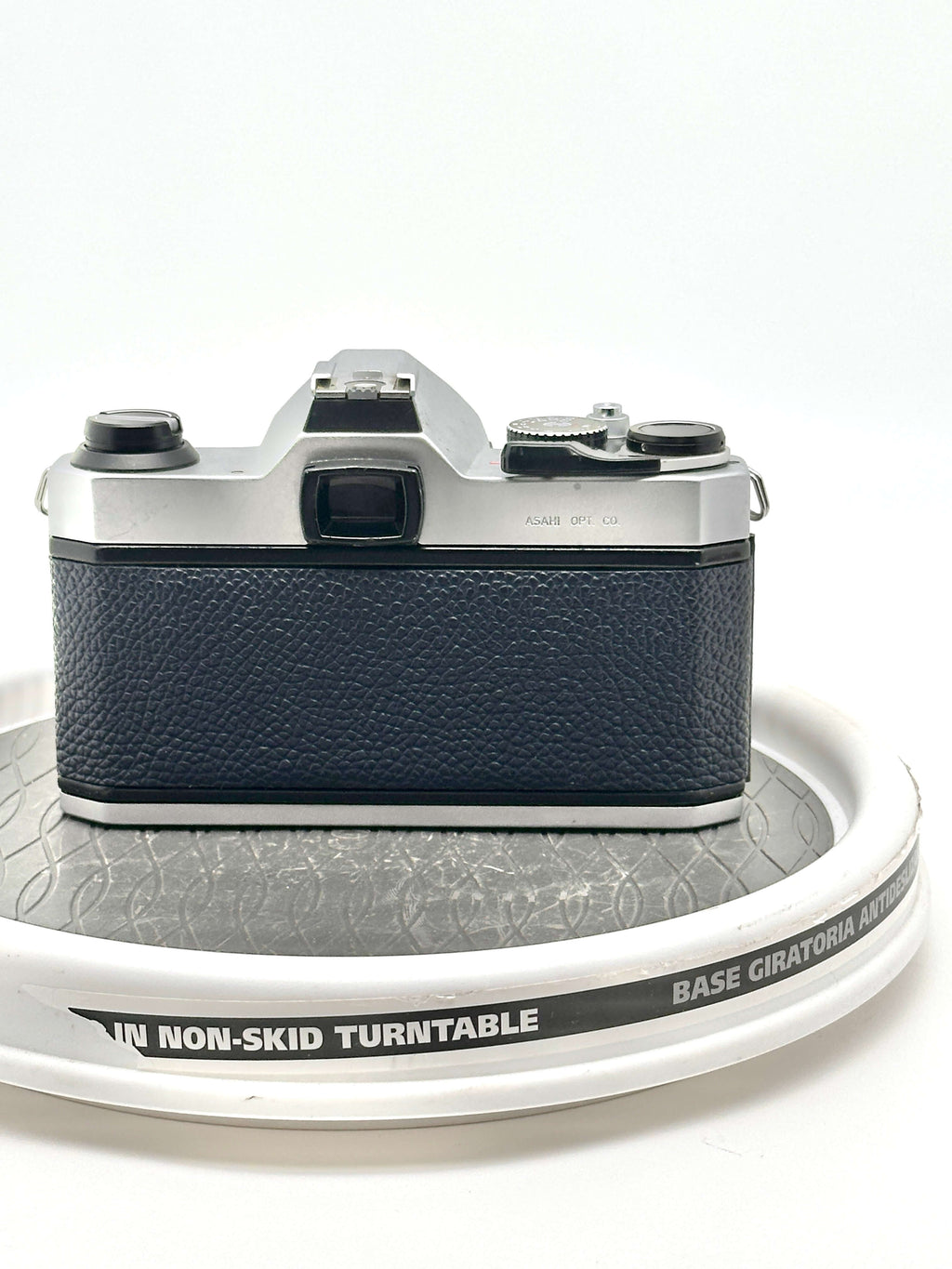 Back view of a Japanese Asahi Pentax K1000 blue 35mm film camera on a non-skid turntable.