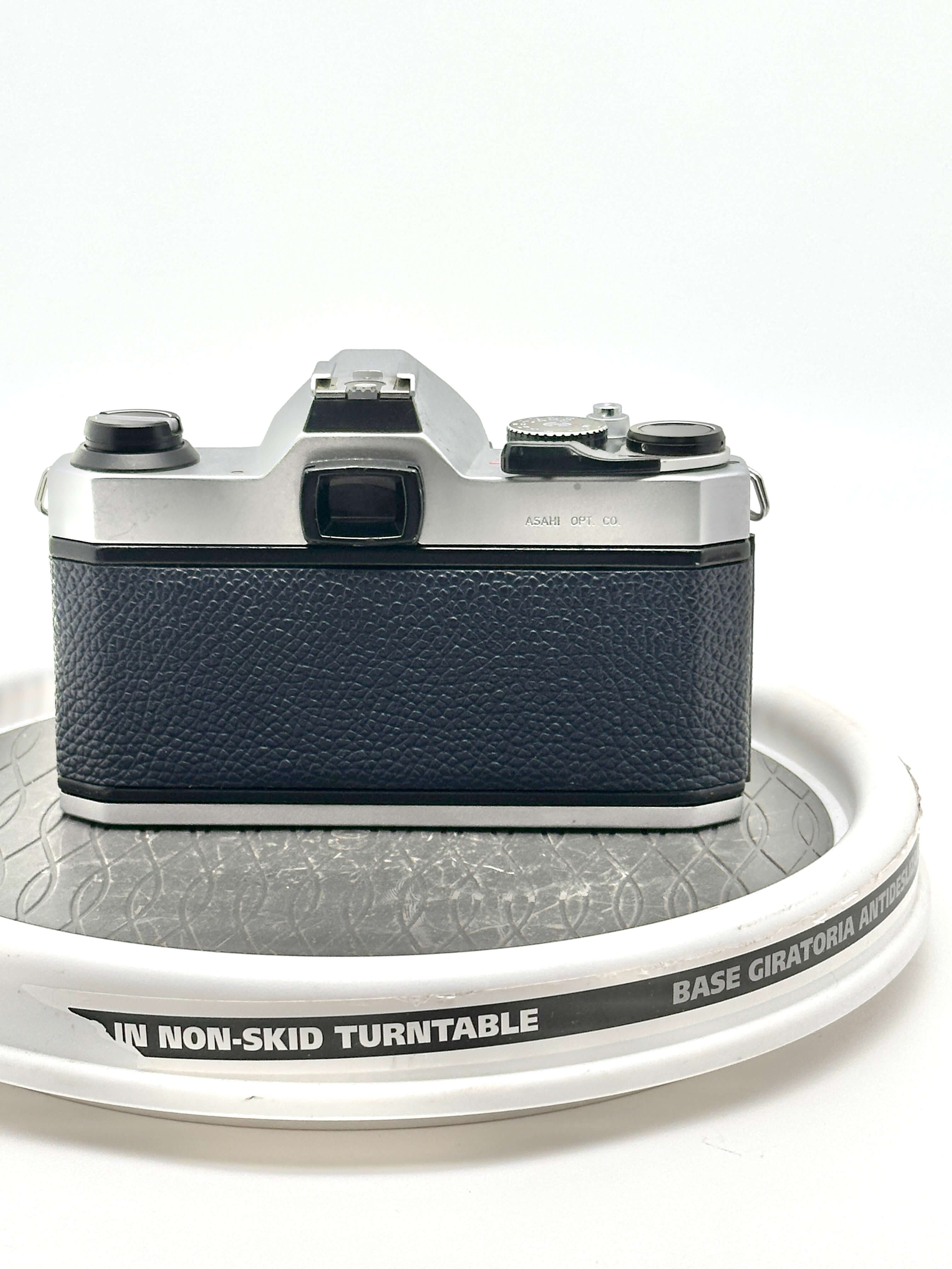 Back view of a Japanese Asahi Pentax K1000 blue 35mm film camera on a non-skid turntable.