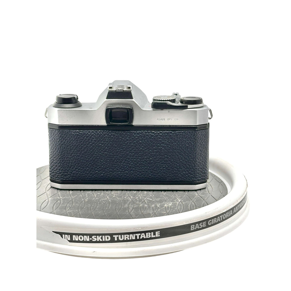 Silver and black vintage camera with textured leather grip.