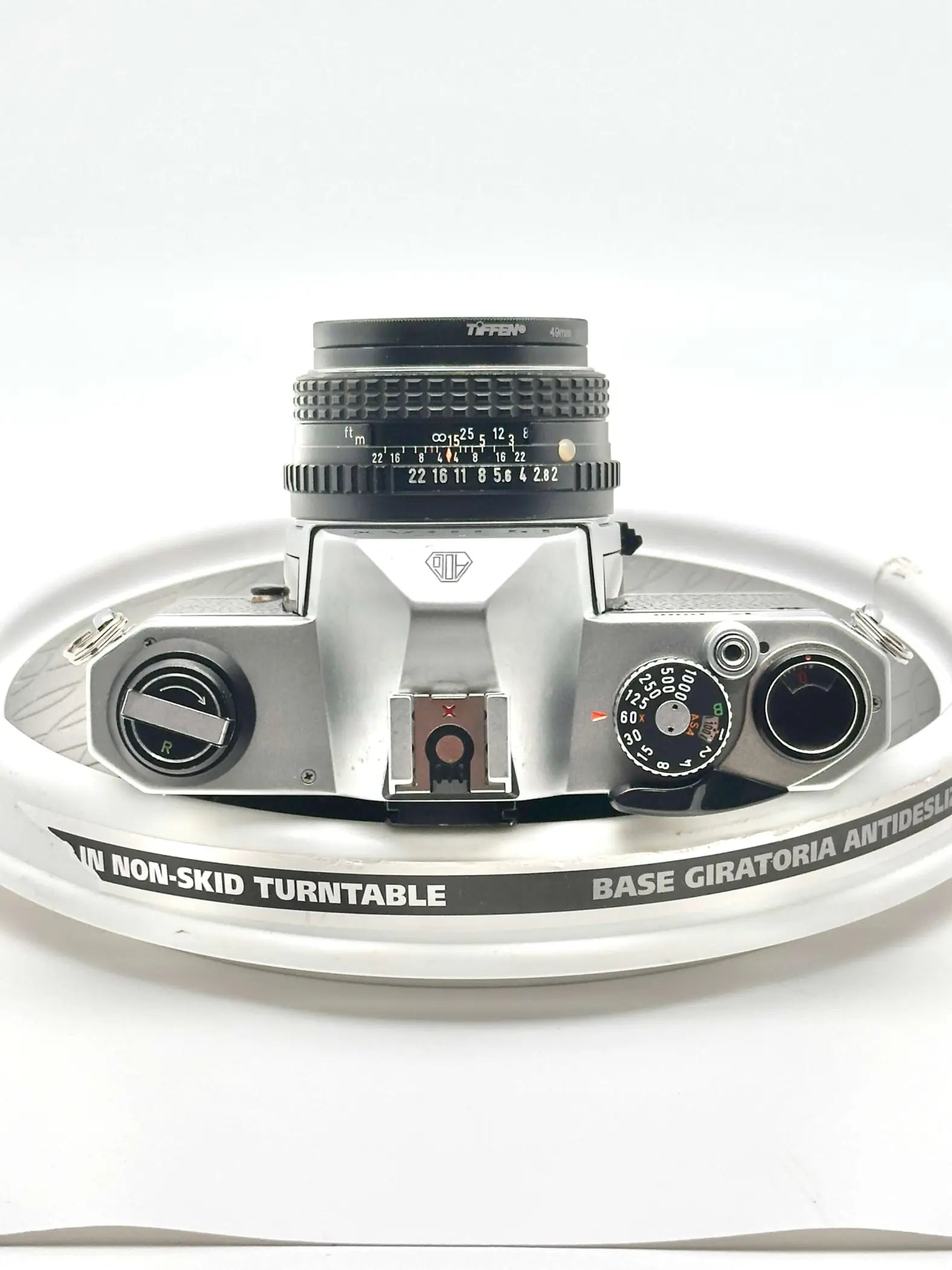 Silver-bodied canon ae-1 film camera with a black tiffen lens mounted on top.