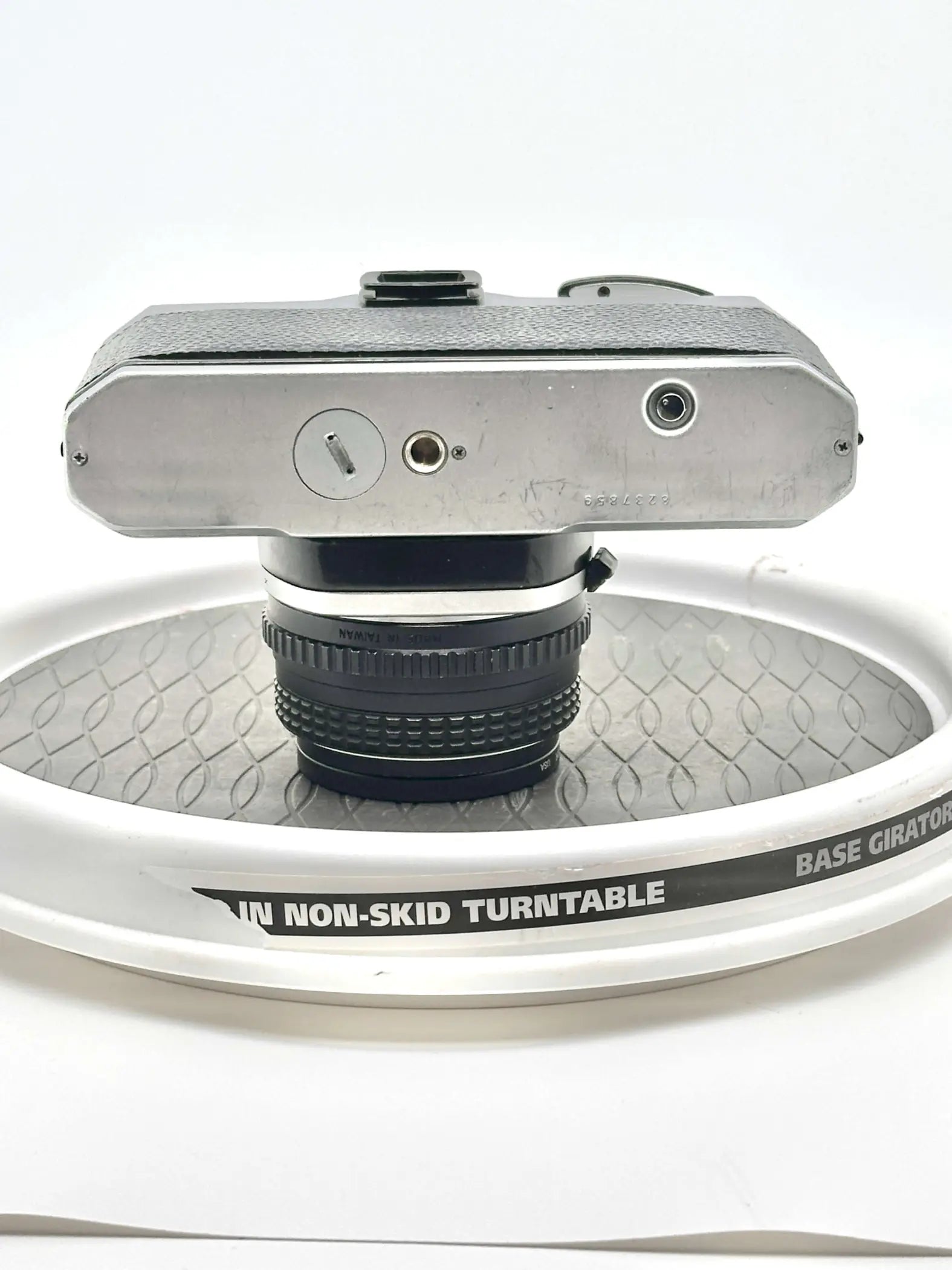 Silver-bodied, textured top camera with a black lens mounted on it.