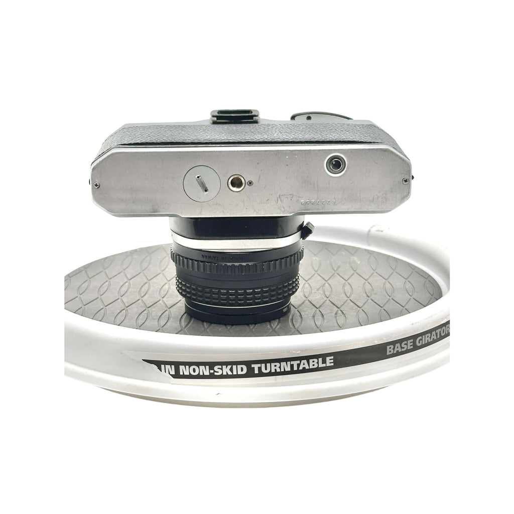 Silver-bodied, textured top camera with a black lens mounted on it.