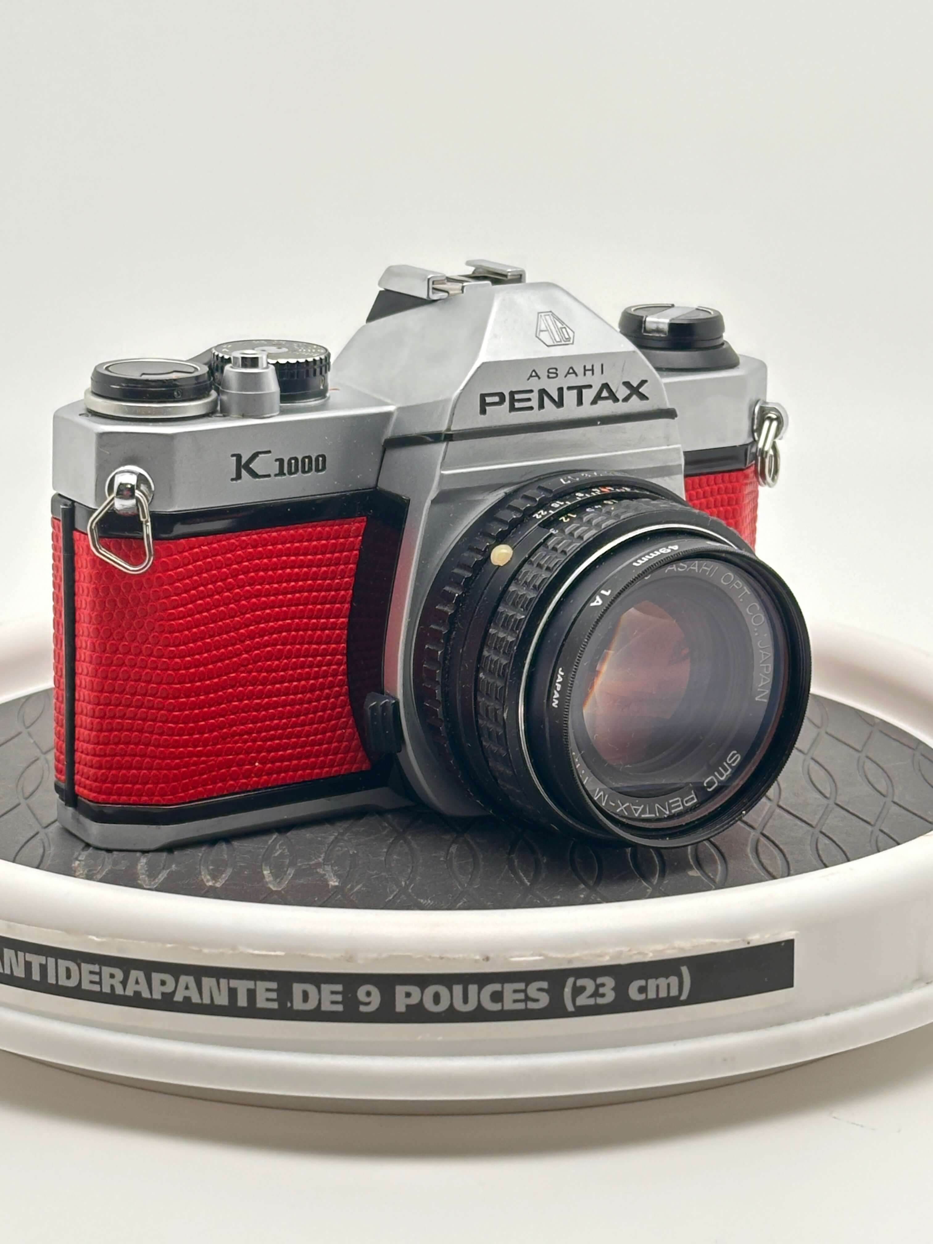 Asahi Pentax K1000 red used 35mm film camera with 50mm f1.7 lens on display.