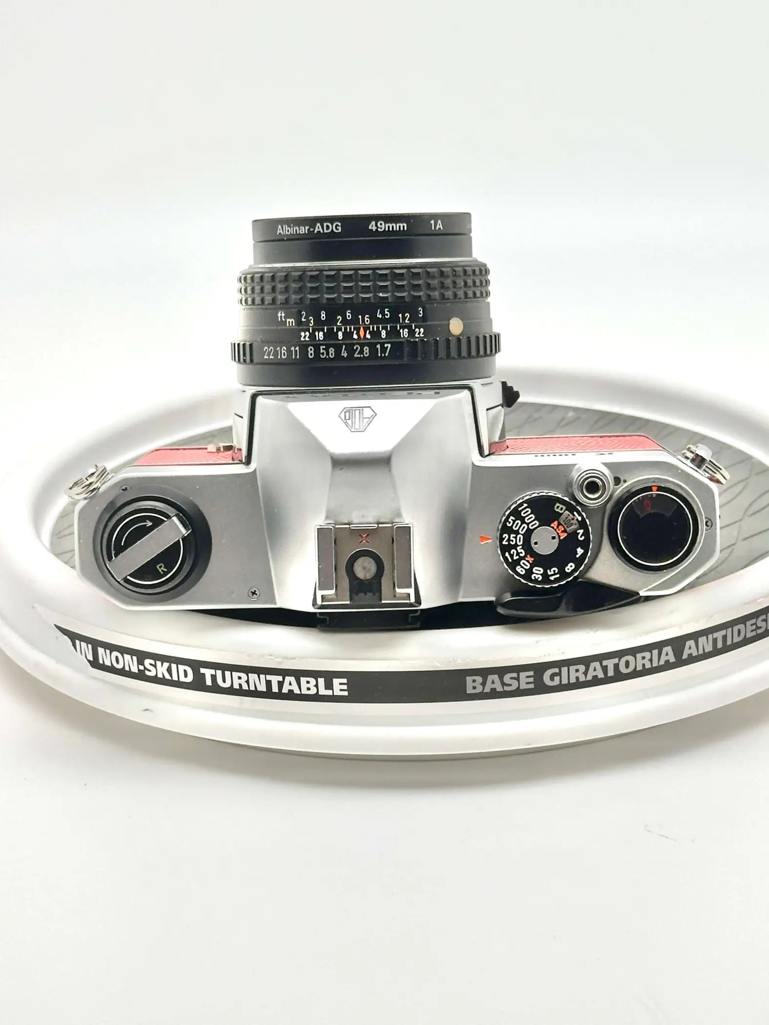 Silver and red albin-adg 49mm lens mounted on a vintage camera body.