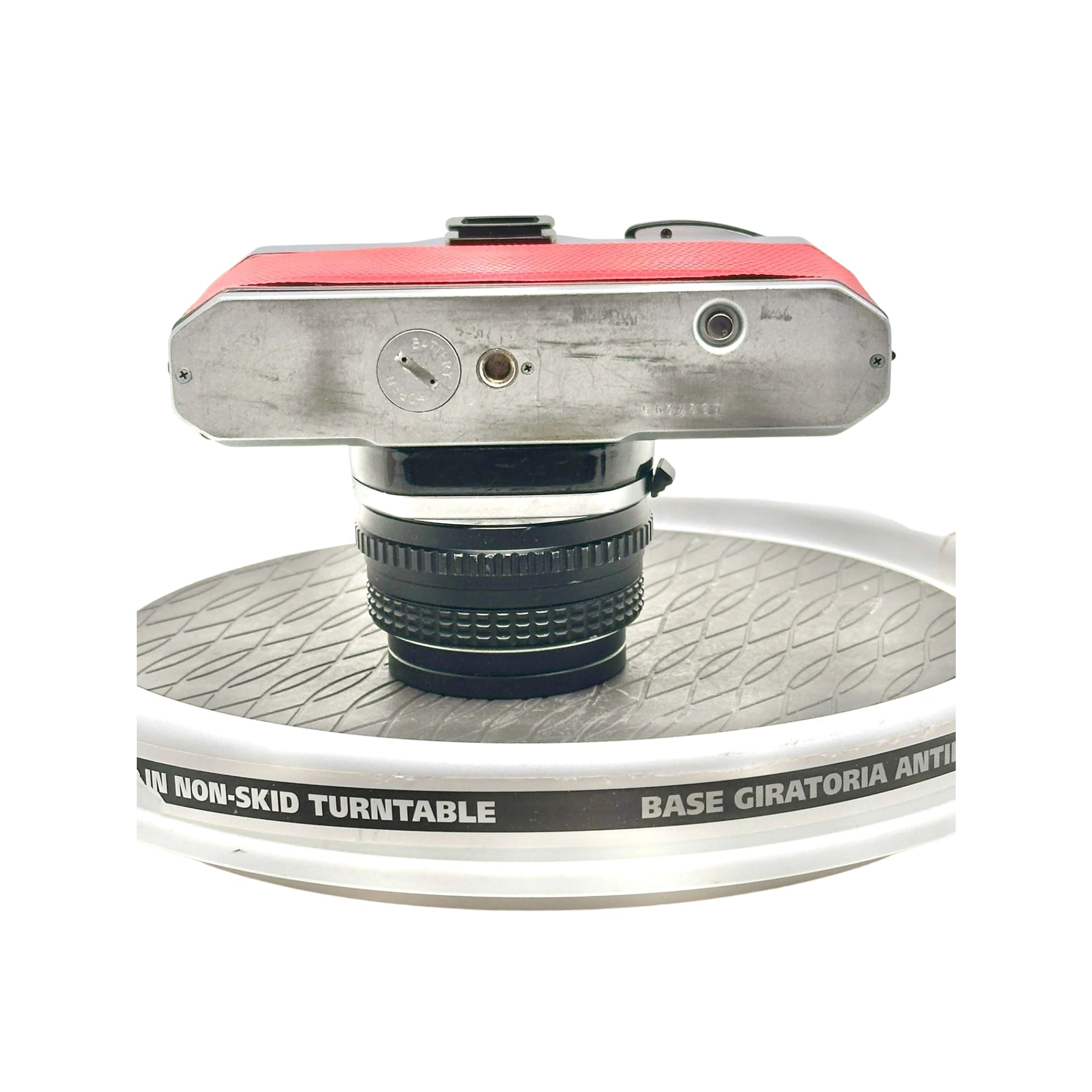 Red and silver vintage camera with a black lens mounted on top.