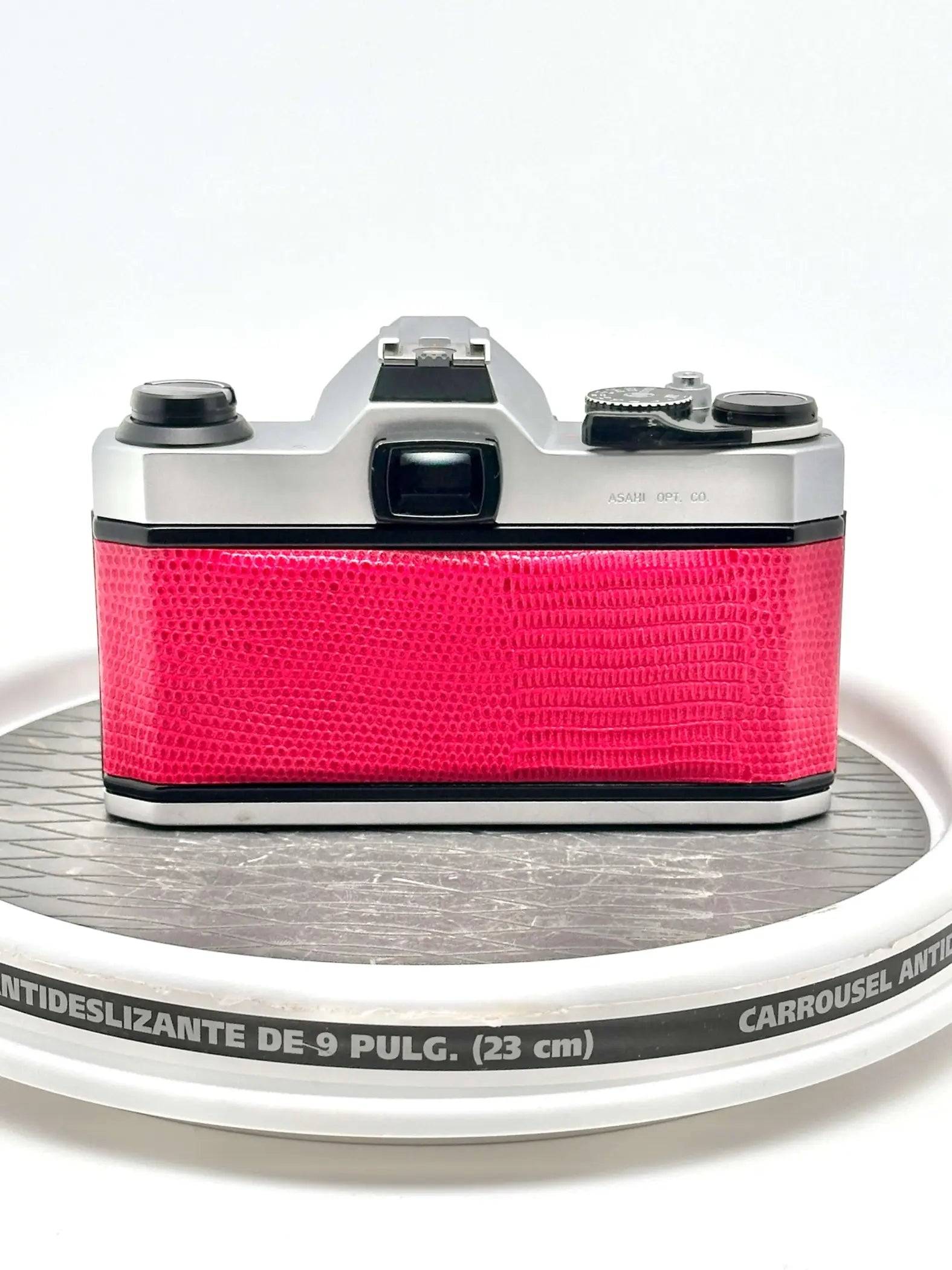 A vibrant pink crocodile-patterned body with silver metallic top and side panels, featuring a classic film camera design.