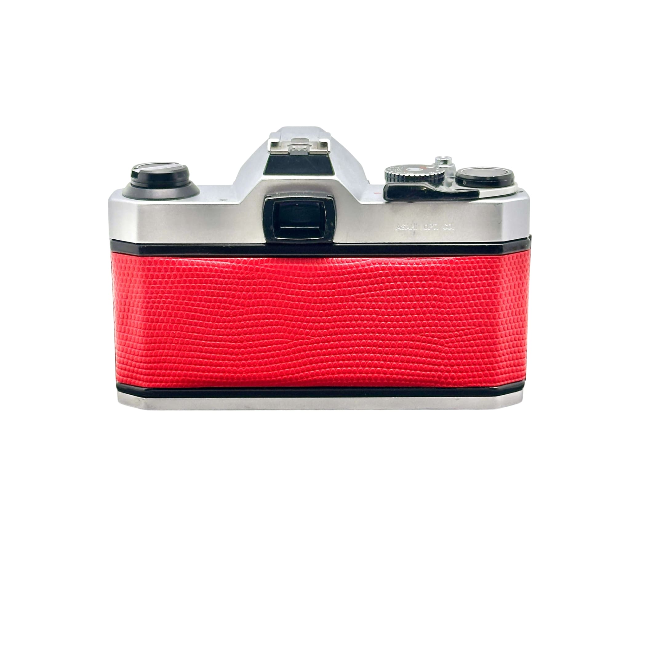 A vintage silver-bodied camera with a vibrant red textured leather grip.