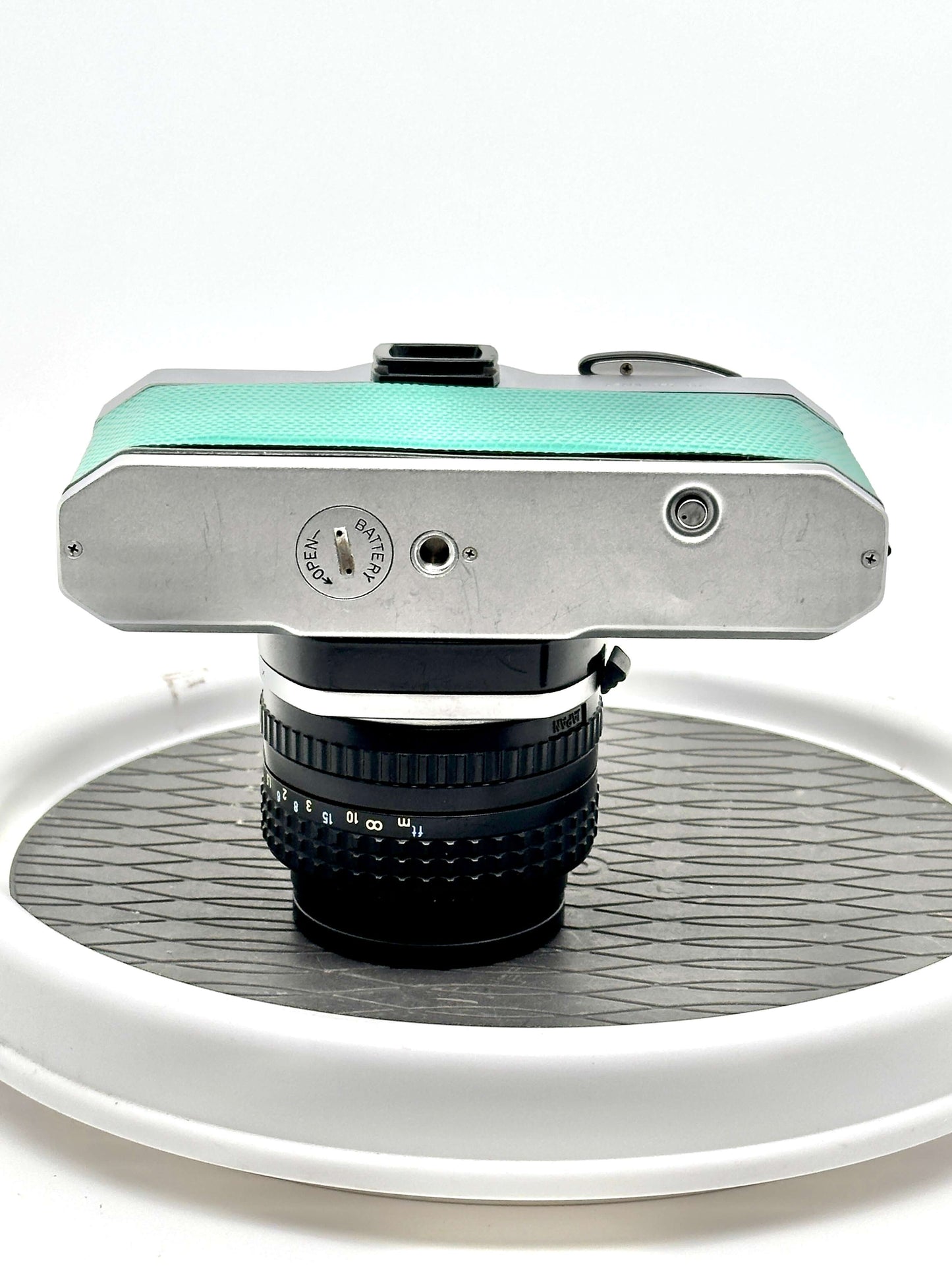 Top view of a teal Japanese Pentax K1000 35mm film camera with 50mm f1.4 lens, showcasing its vintage design.
