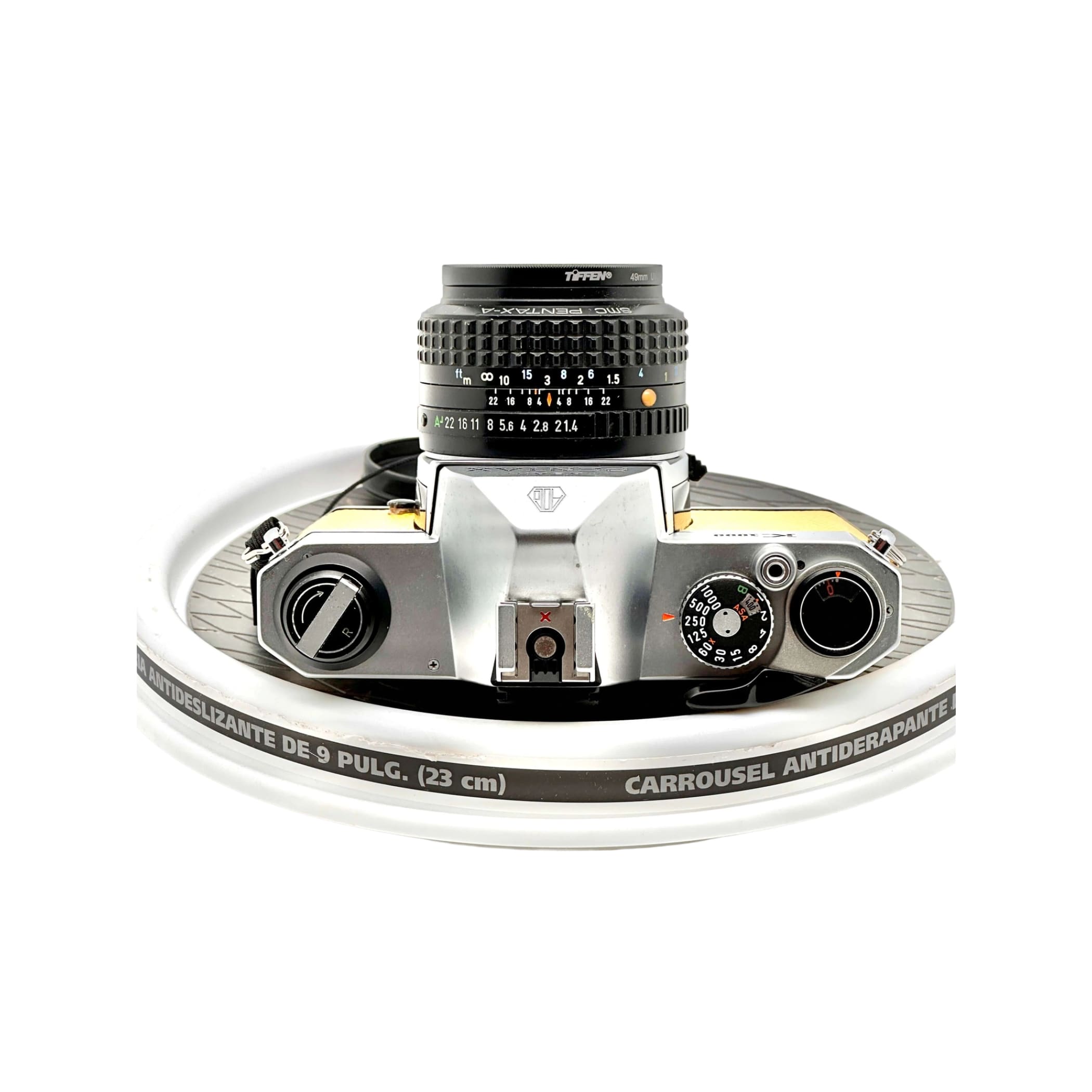 Silver and yellow-bodied canon ae-1 film camera with a black tiffen lens mounted on top.