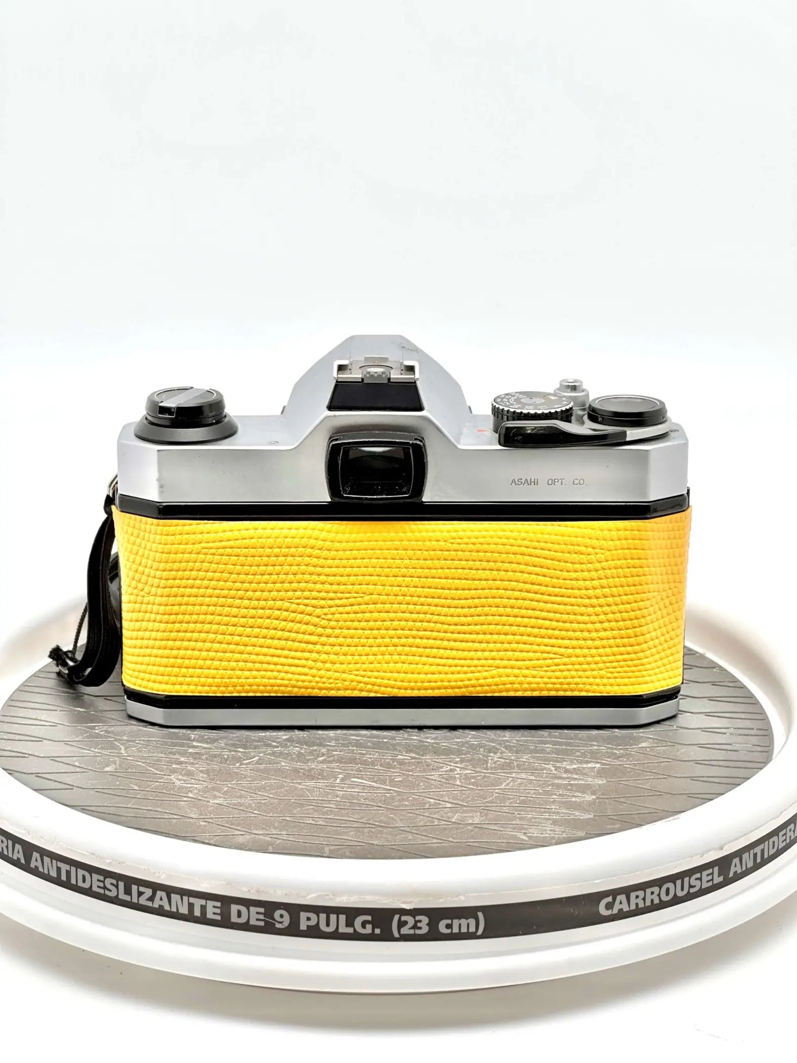 A vibrant yellow textured leather body with silver metal accents, featuring a classic camera design.