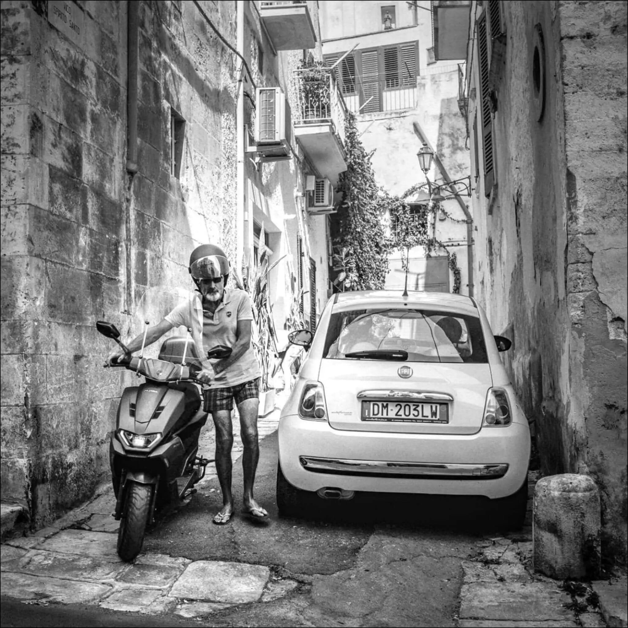 White fiat 500 parked in a narrow alleyway