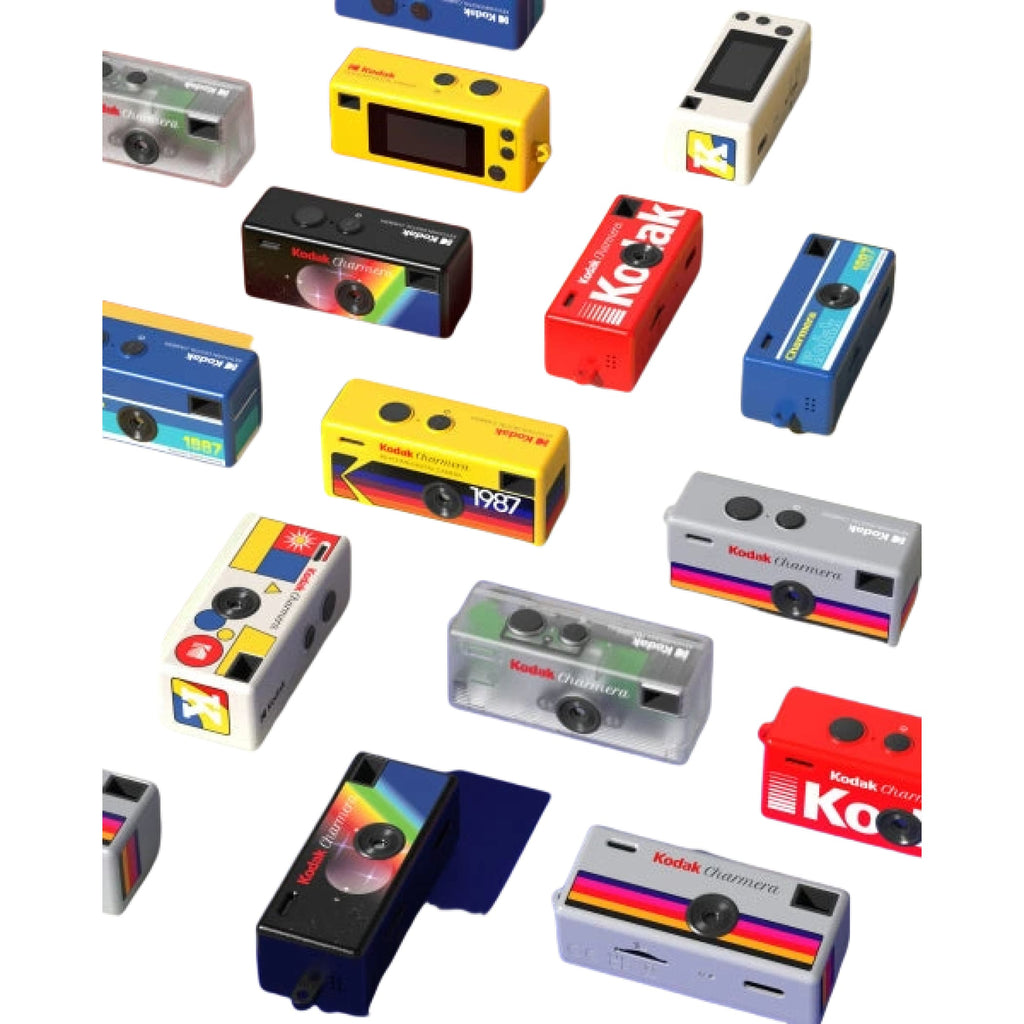 A vibrant collection of kodak champion instant cameras in assorted colors and designs, including transparent, black, red, blue, yellow, and white models with rainbow stripes.