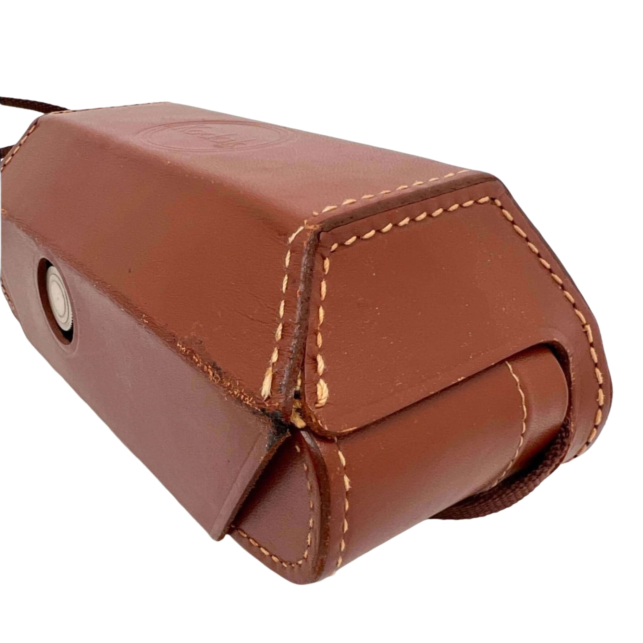 Brown leather camera case with tan stitching and a circular metal clasp.
