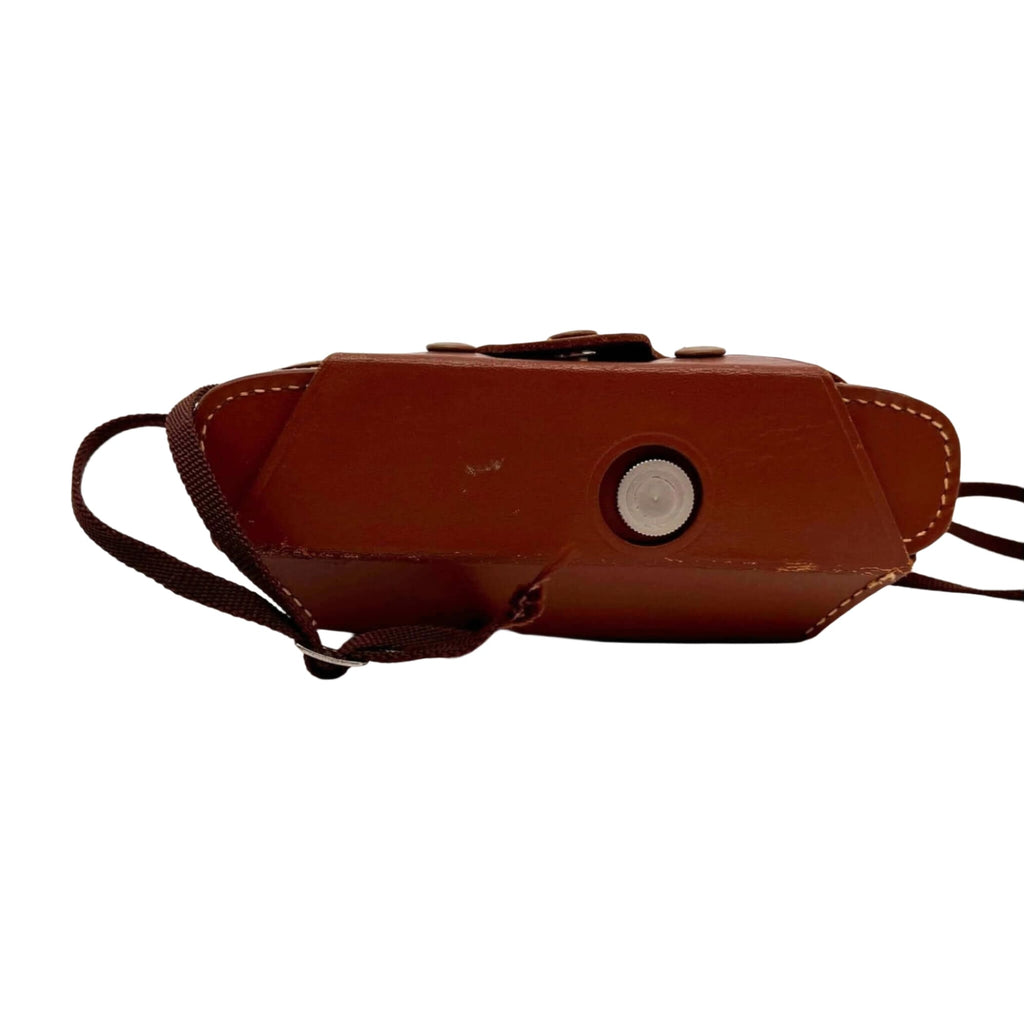 Brown leather camera case with a circular silver button and stitched edges.