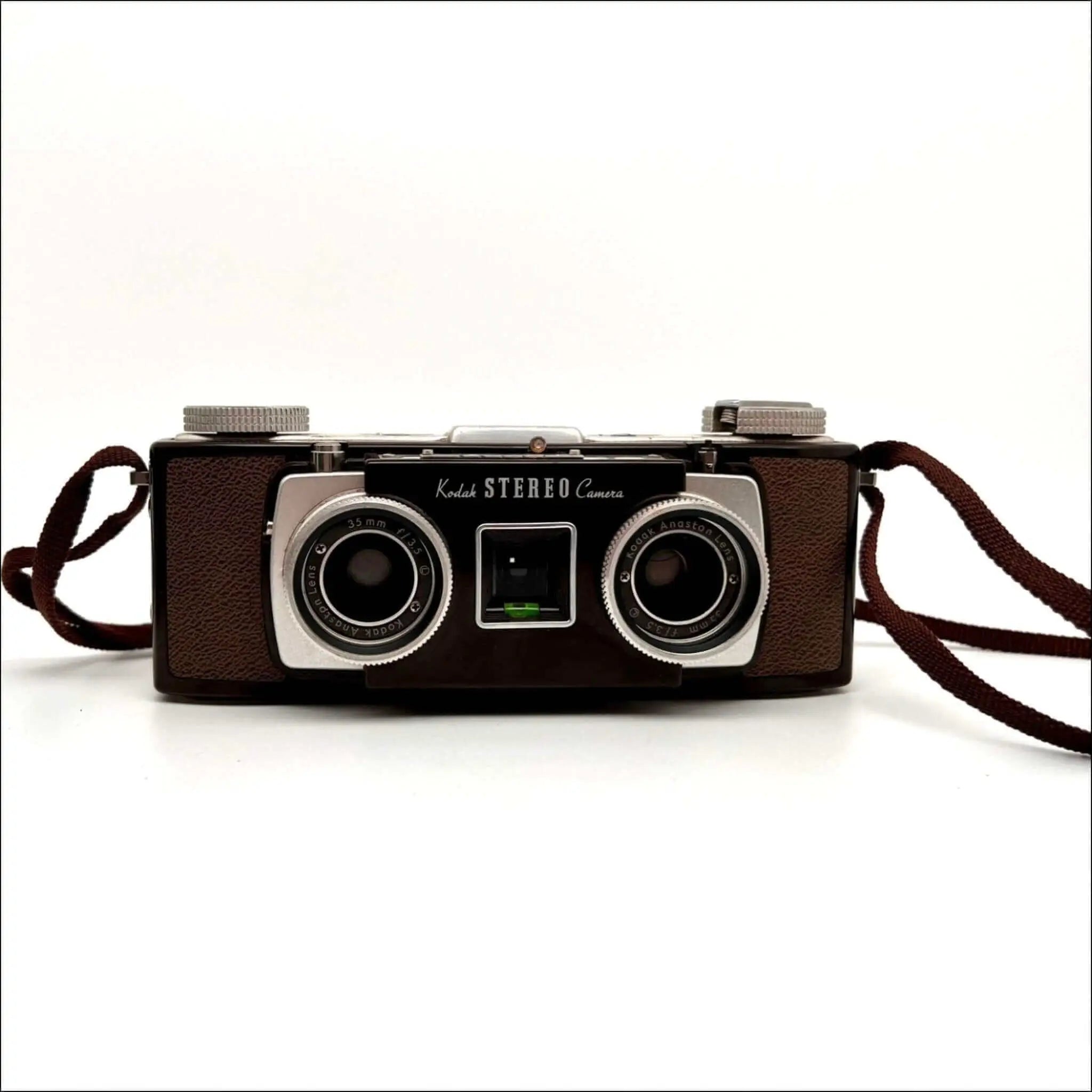 Brown leather-bodied kodak stereo camera with two silver-rimmed lenses and a matching brown strap.