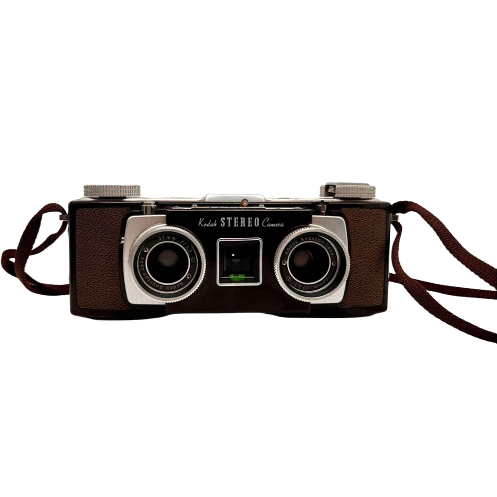 Brown leather-bodied kodak stereo camera with two silver-rimmed lenses and a matching brown strap.