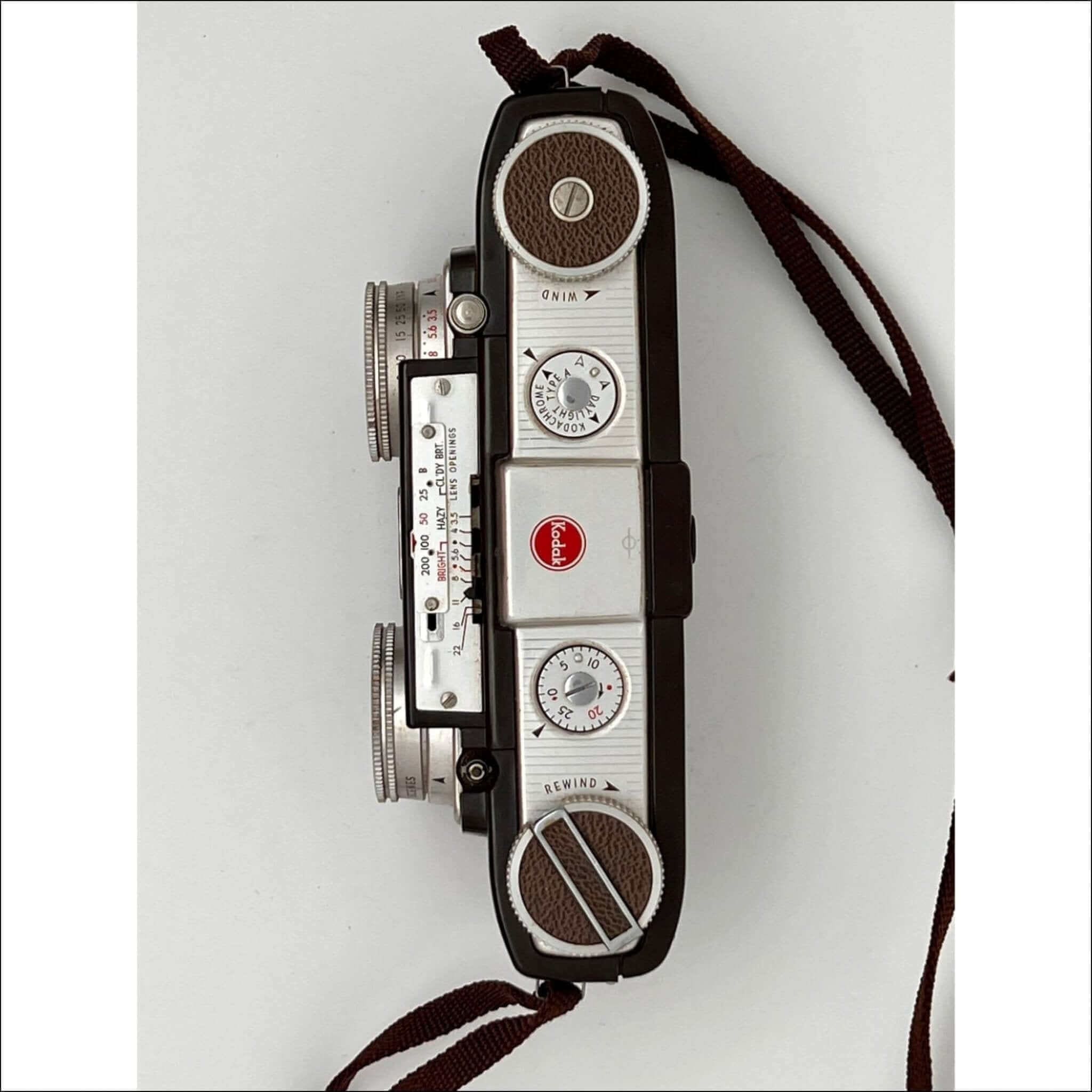 Vintage kodak brownie camera with a silver and black body, brown leather accents on the dials, and classic film rewind and wind knobs.