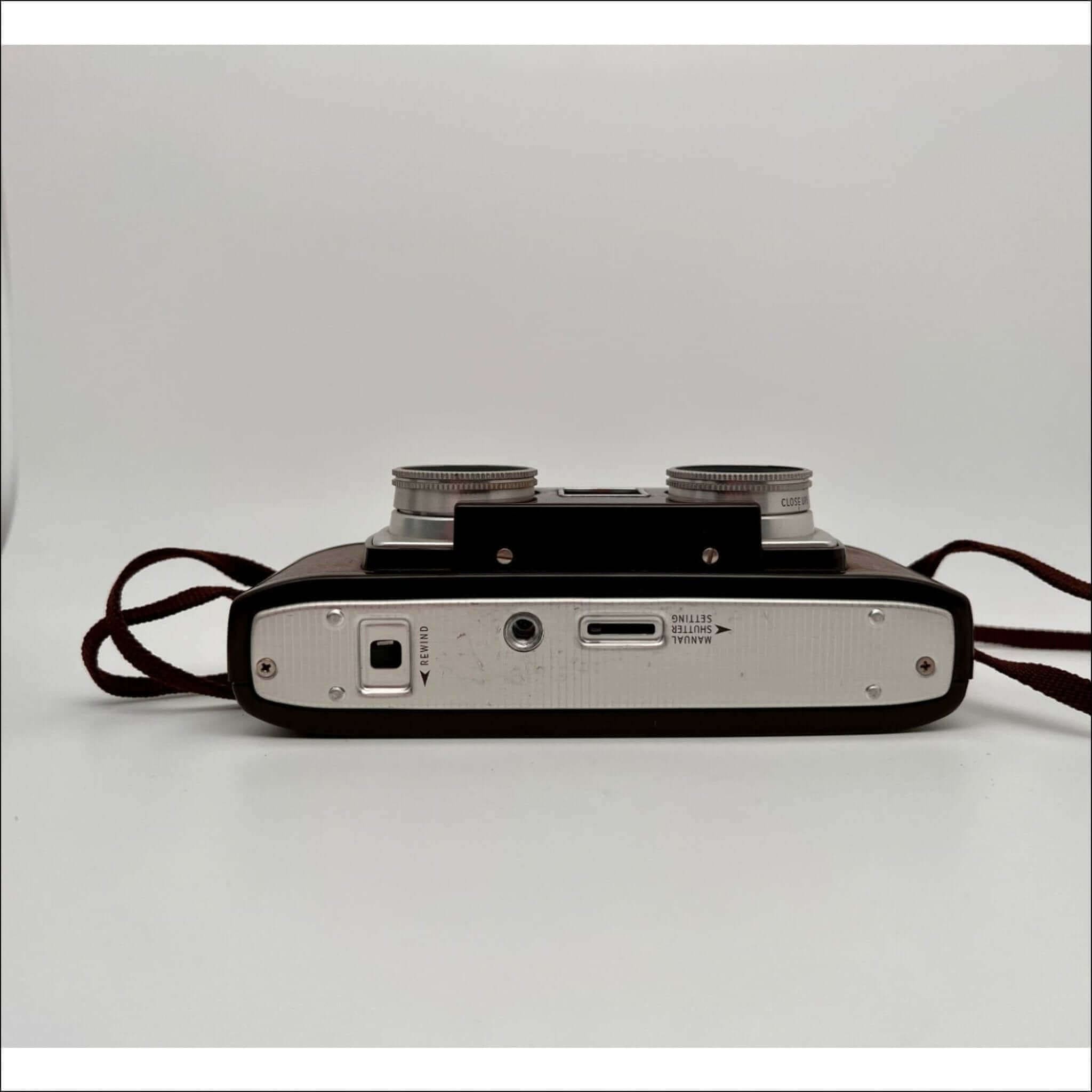Vintage twin-lens reflex camera with a black body and silver metal accents, featuring two circular lenses on top.