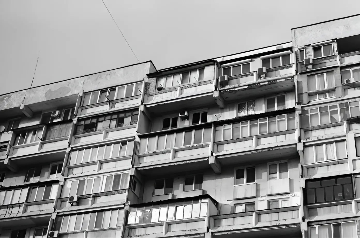 Weathered concrete apartment building with multiple balconies and windows