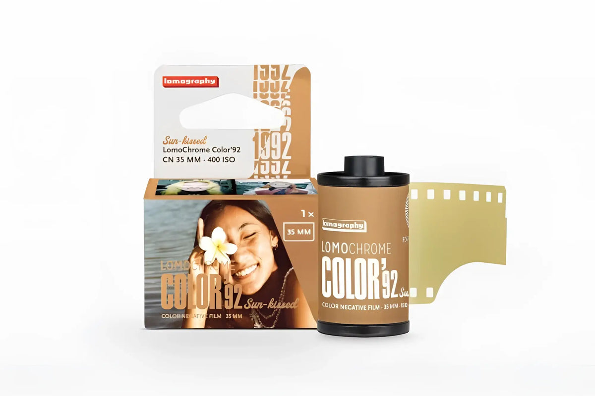 Lomography lomochrome color 92 sun-raised color negative film in a tan cardboard box with black and white text, featuring a smiling woman holding a flower.