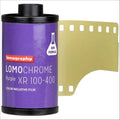 Purple lomography lomochrome purple xr 100-400 color negative film canister with a gold-colored strip of photographic film partially unspooled.